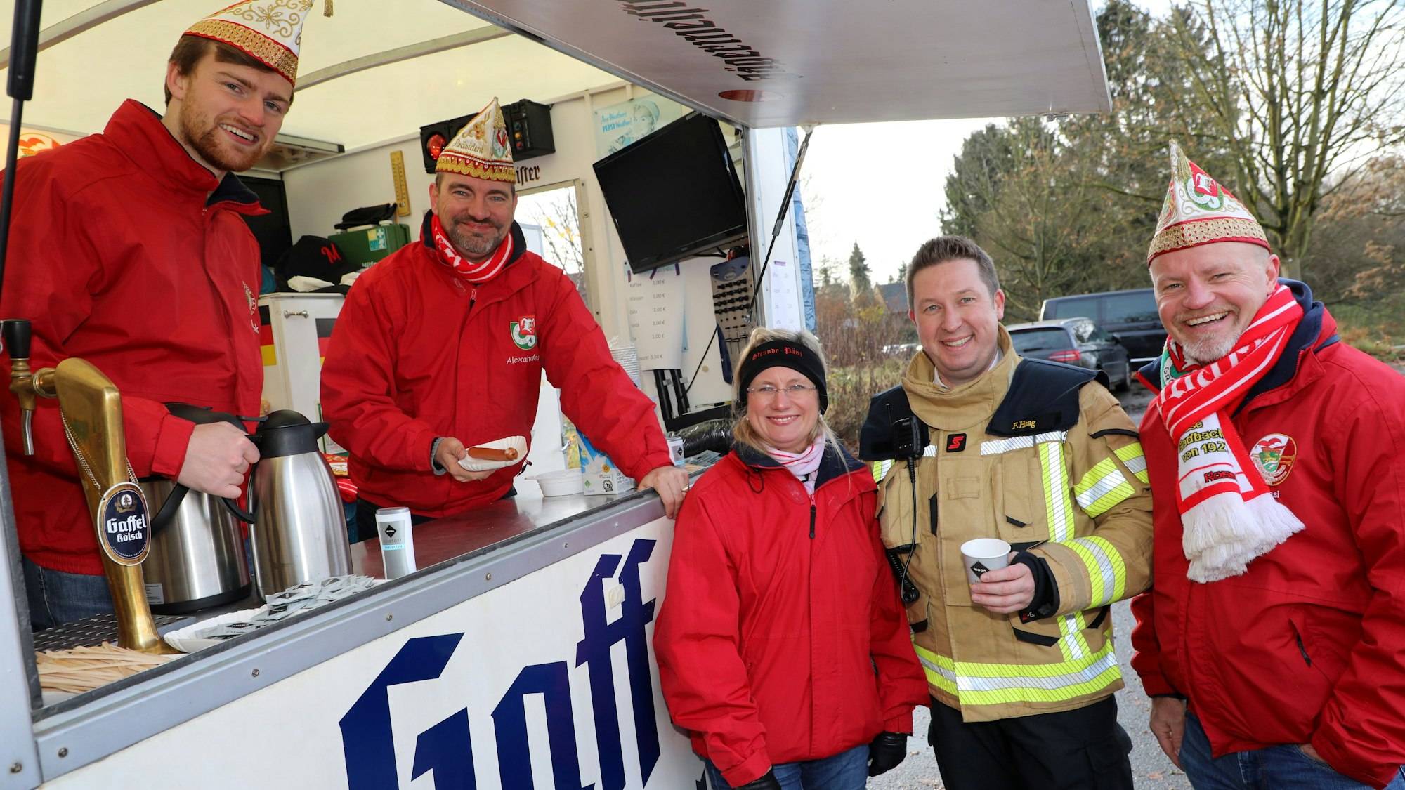 Das Dreigestirn und der KG-Präsident stehen an der Getränkebude beim Impf-drive-in der Bergisch Gladbacher Feuerwehr.