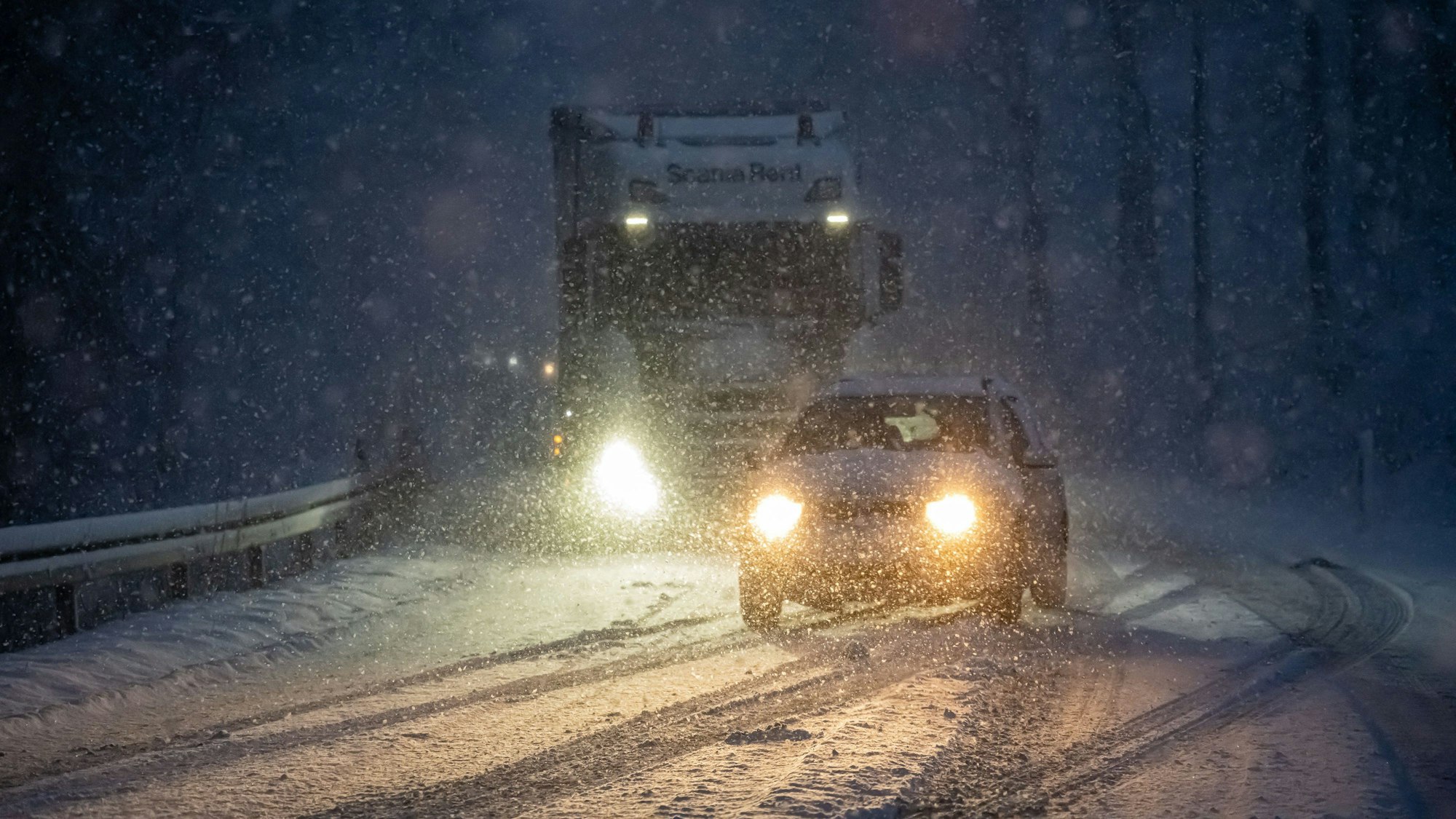 Ein Auto überholt einen Lastwagen, der auf der schneebedeckten Fahrbahn an einer Steigung liegen geblieben ist (Archivfoto).