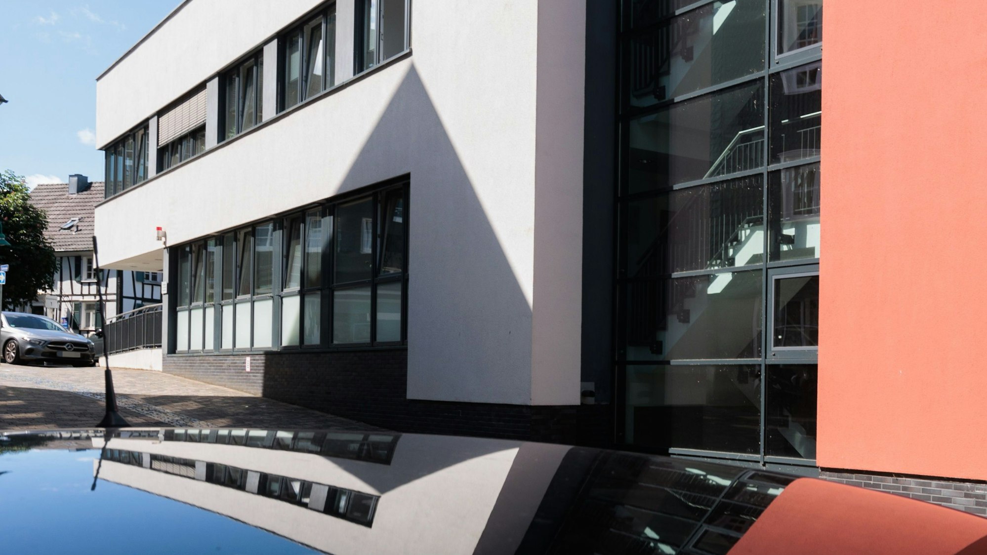 Zu sehen ist der Eingang des Amtsgerichts in Waldbröl, ein rot und weiß gestrichenes Gebäude.