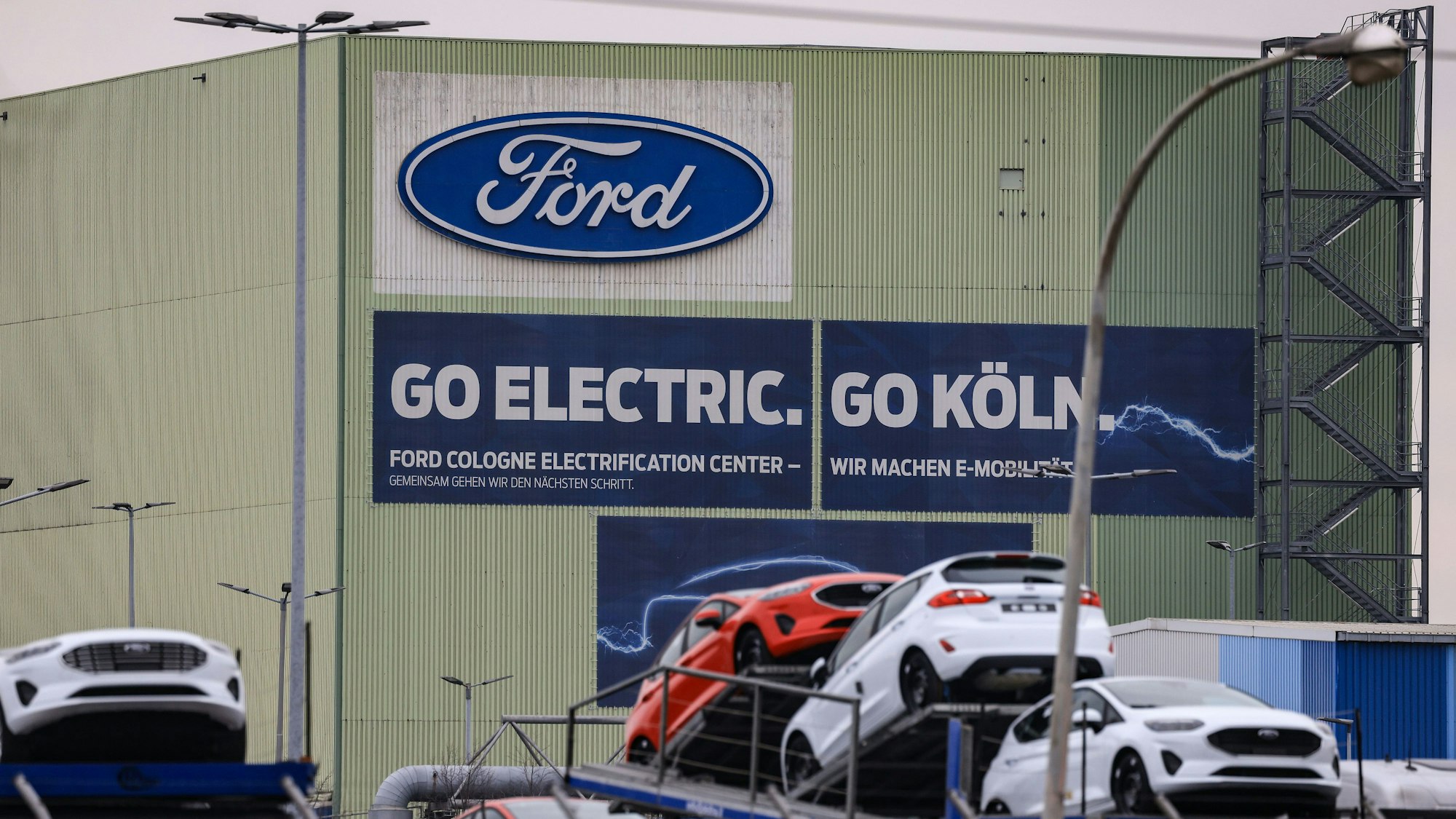 Neufahrzeuge von Ford vor einer Halle im Kölner Ford-Werk.