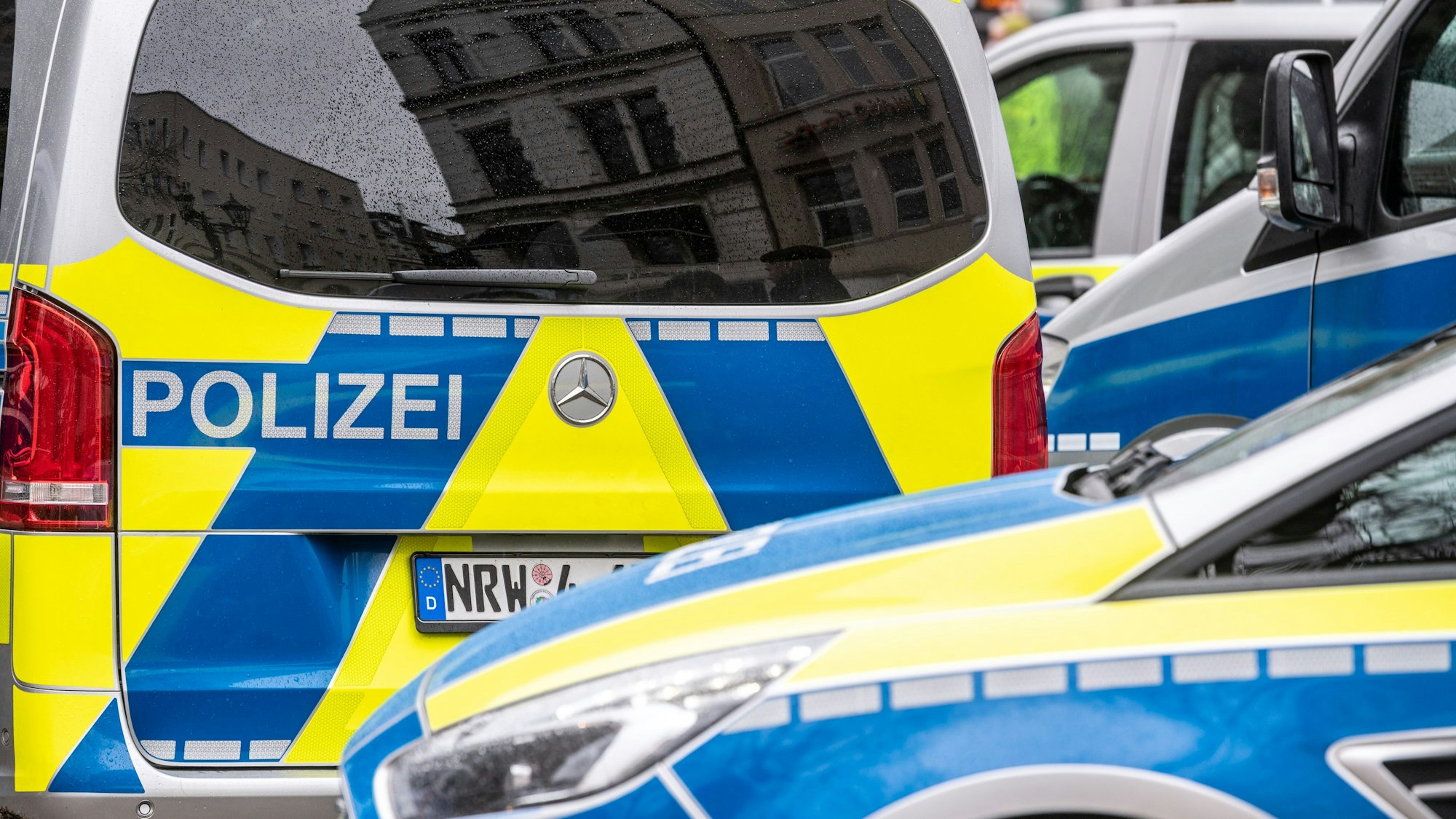 Zwei Polizeifahrzeuge stehen vor einer Polizeiwache. (Symbolbild)