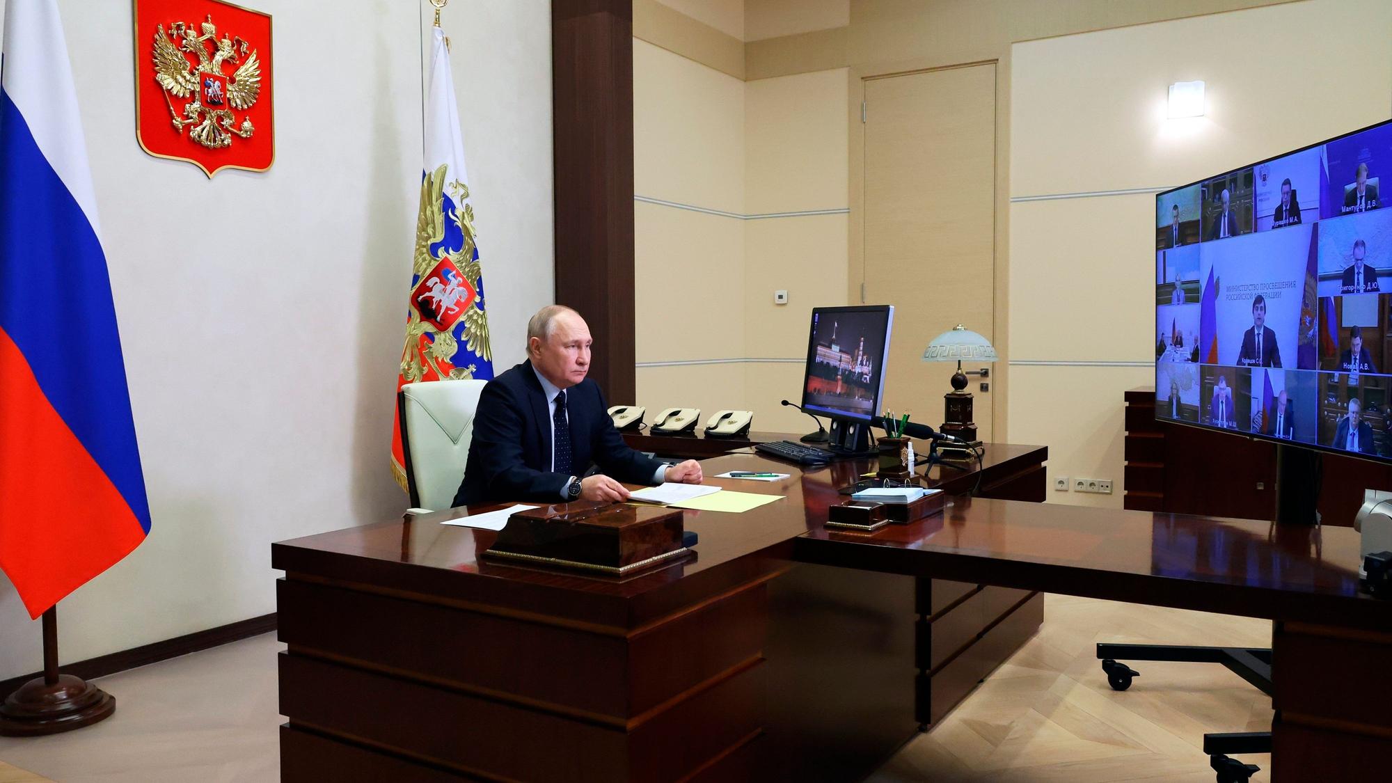 Der russische Präsident Wladimir Putin sitzt während einer Videokonferenz an seinem Schreibtisch.