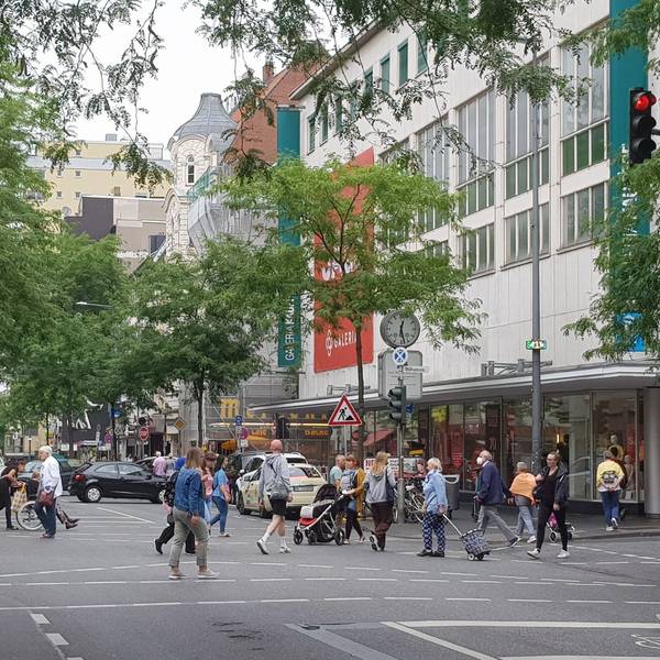 Viele Fußgänger gehen an der Kaufhof-Filiale über die Neusser Straße in Nippes.