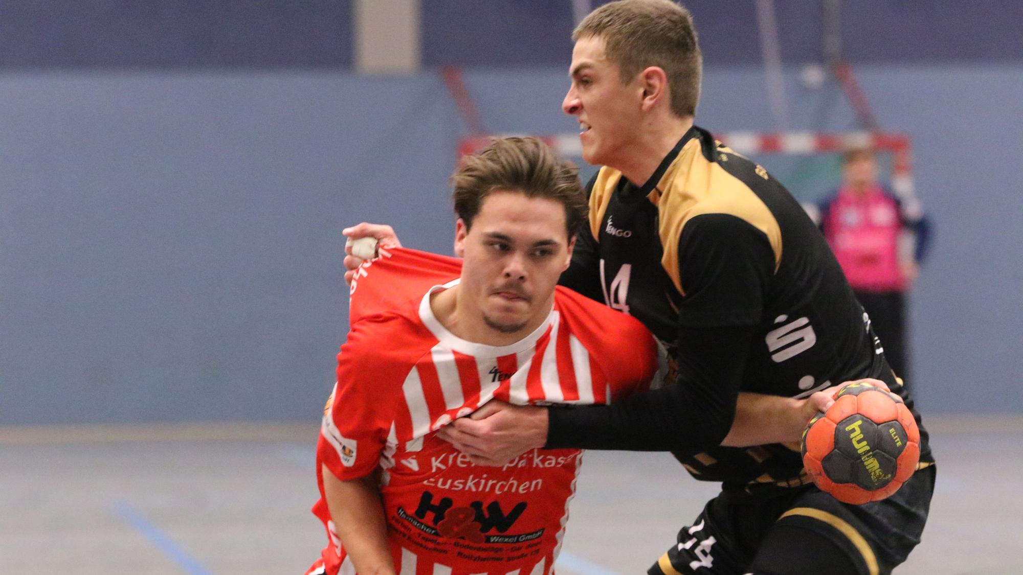 Zwei Spieler der HSG Euskirchen und des TVE Bad Münstereifel kämpfen um einen Ball.