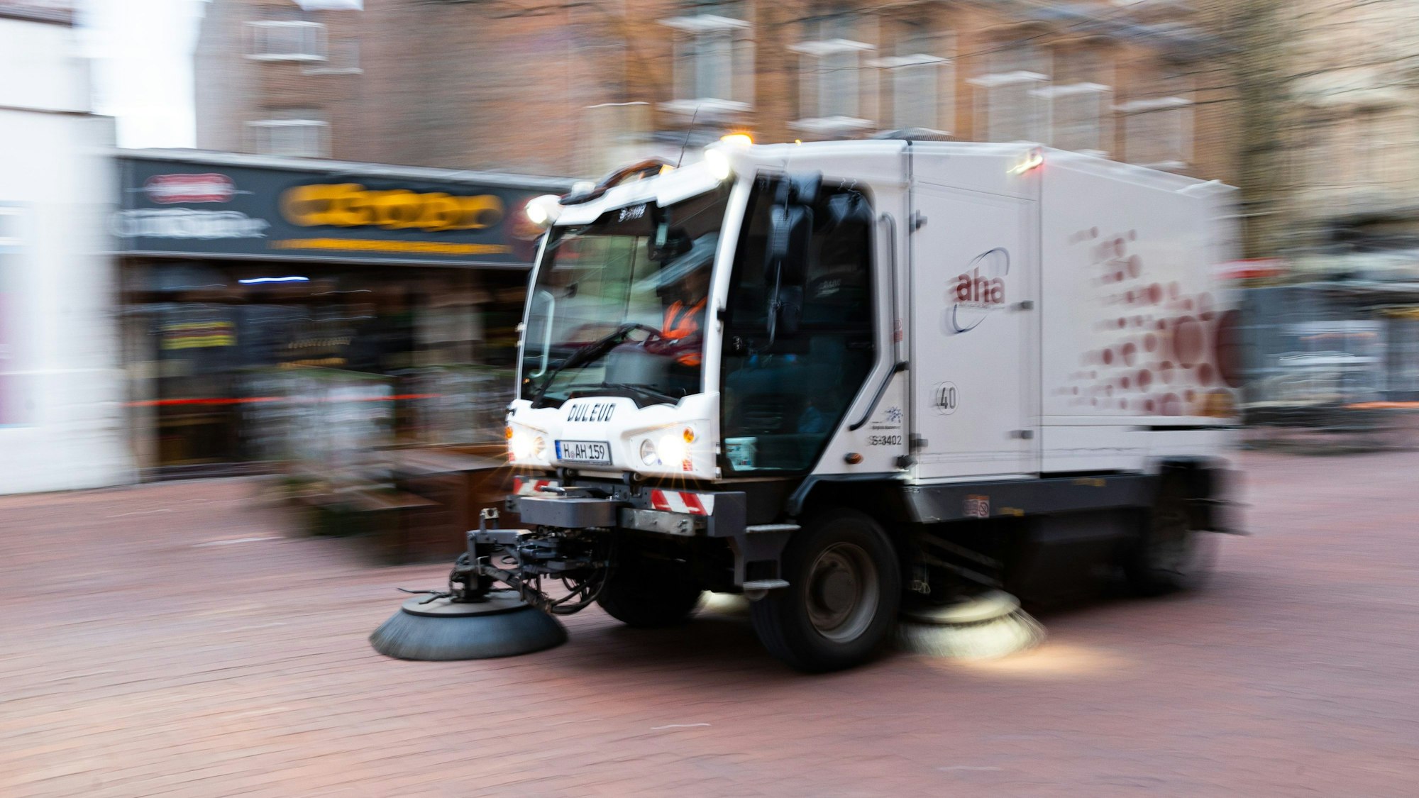Eine Kehrmaschine fährt in einer Fußgängerzone.
