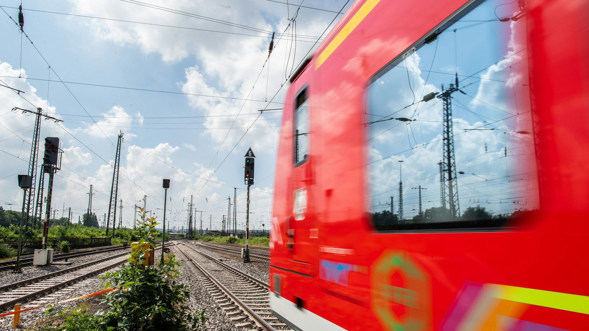 In der Scheibe einer Regionalbahn, die Richtung Dortmund fährt, spiegeln sich Hochspannungsleitungen. (Symbolbild)