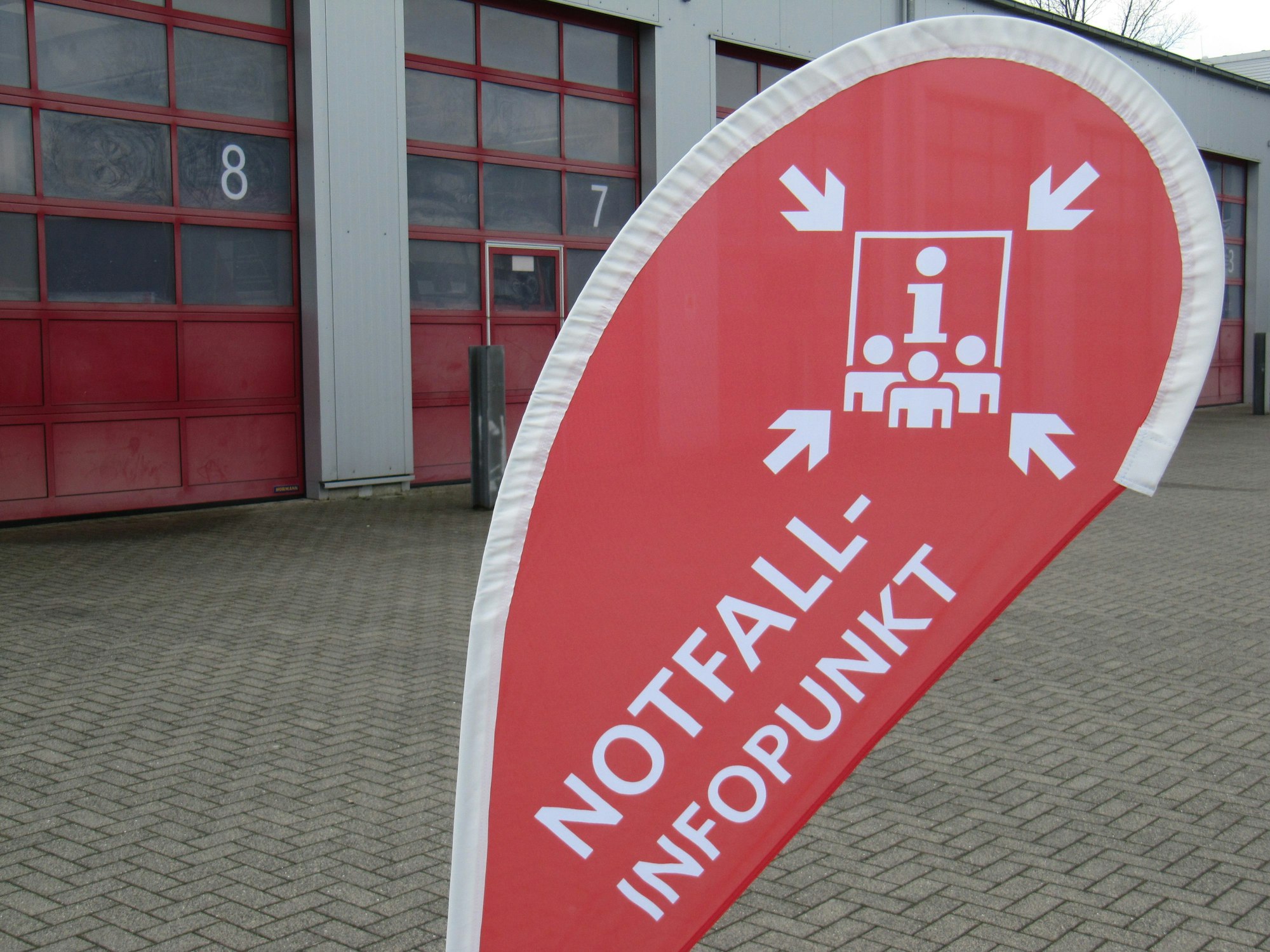 Ein rotes Banner steht vor einer Wache der Feuerwehr.