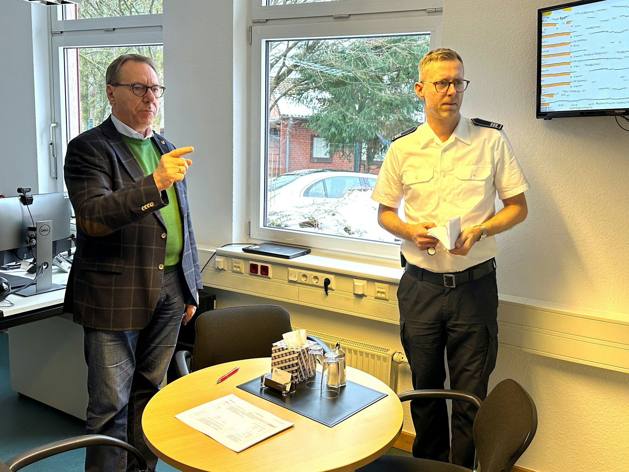 Zwei Männer blicken auf einen Bildschirm.