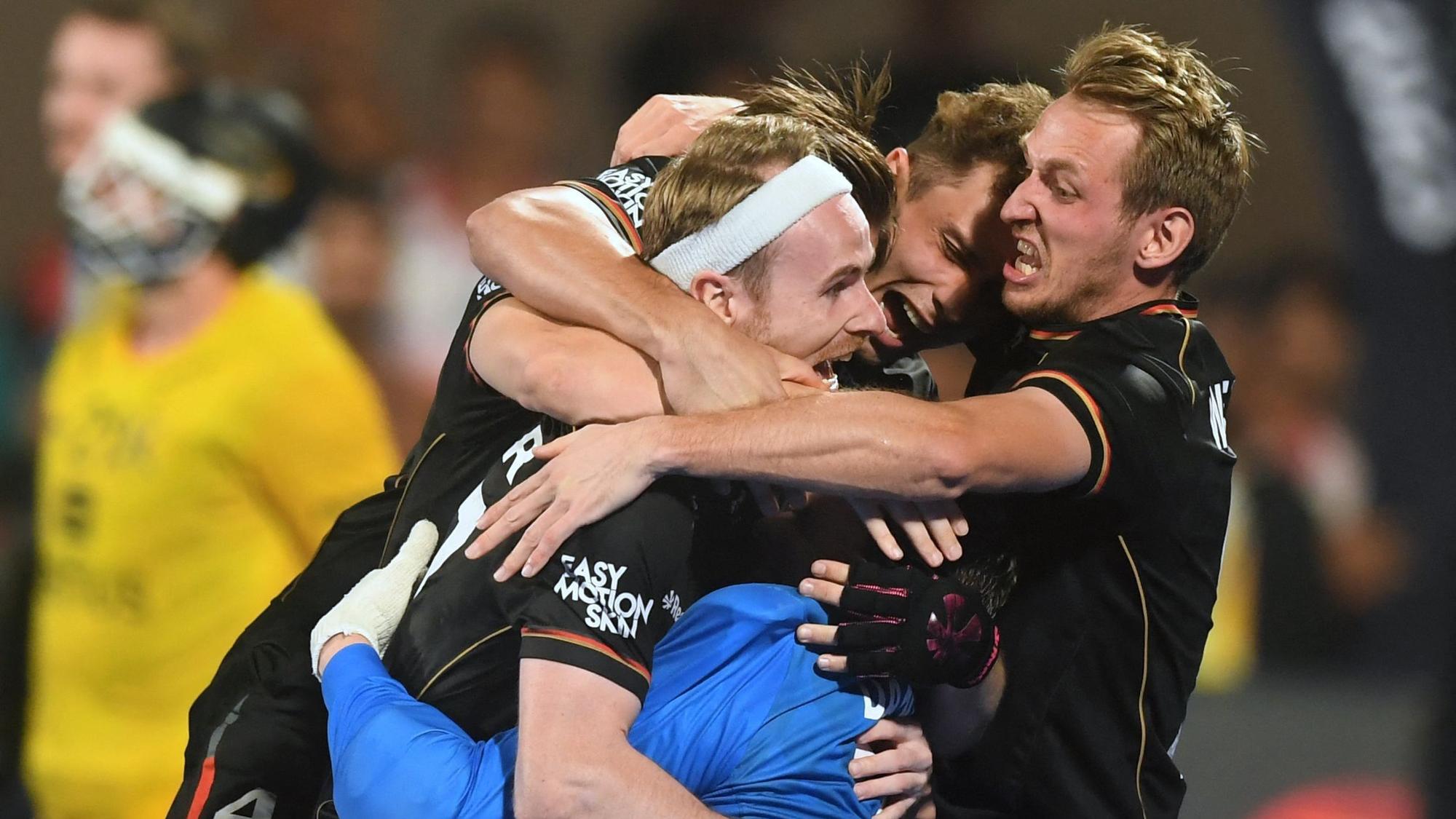 Spieler der deutschen Hockey-Nationalmannschaft liegen sich nach dem WM-Triumph in den Armen.