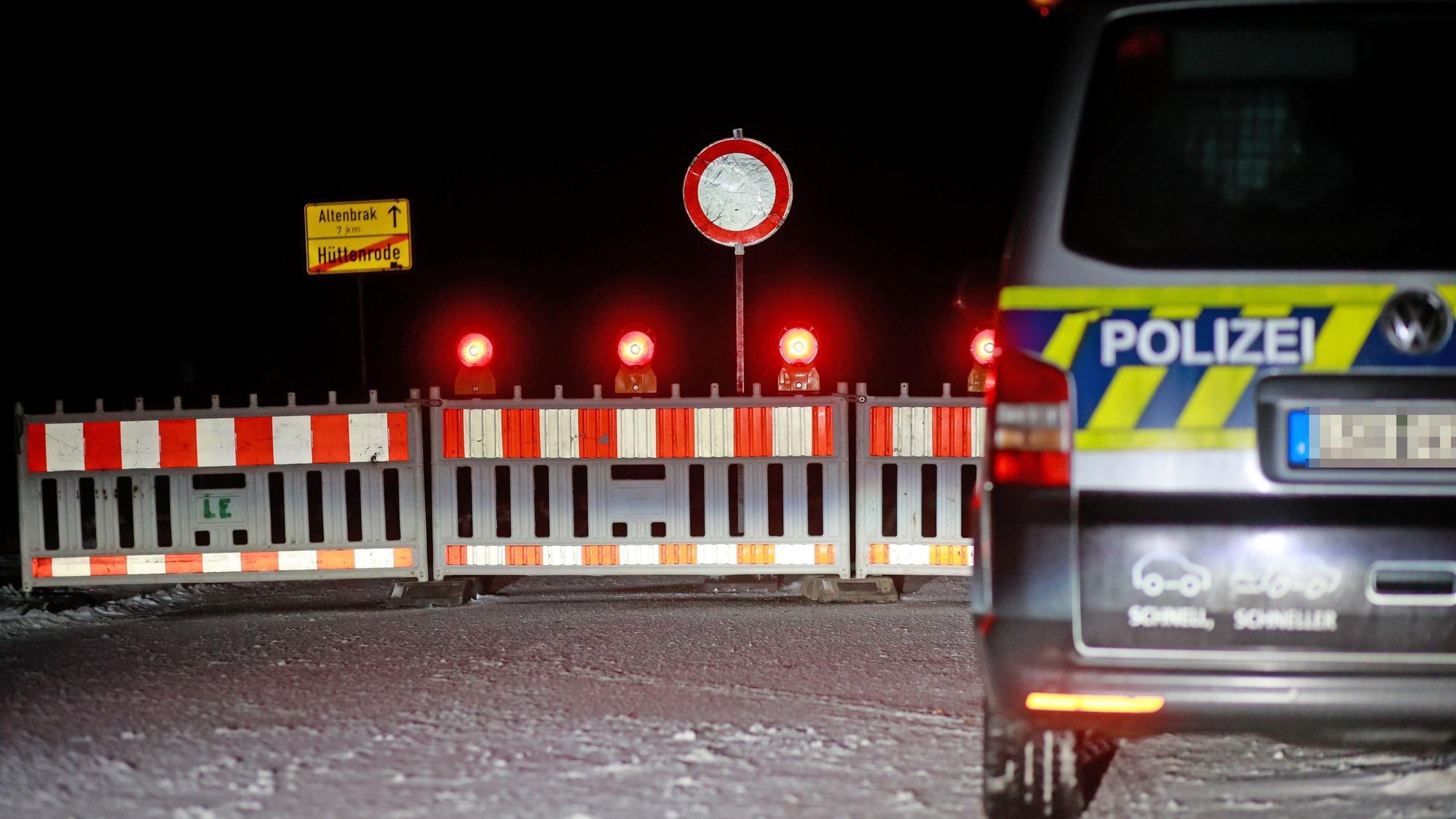 Es ist eine Straßensperrung zu sehen. Auf der rechten Seite steht ein Polizeiwagen.