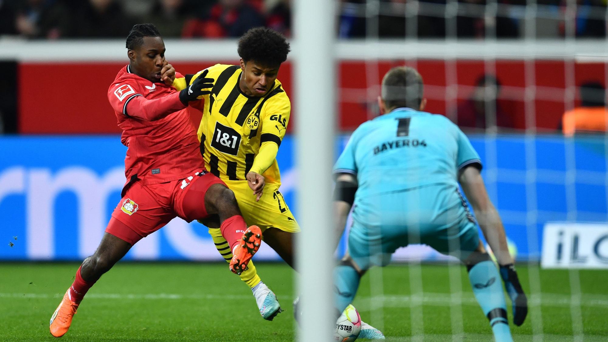 Dortmunds Karim Adeyemi (M) und Leverkusens Jeremie Frimpong kämpfen um den Ball.