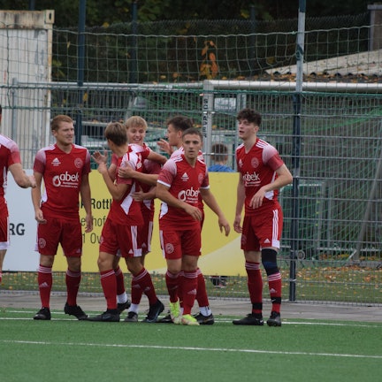 Spieler des Heiligenhauser SV in roten Trikots jubeln.