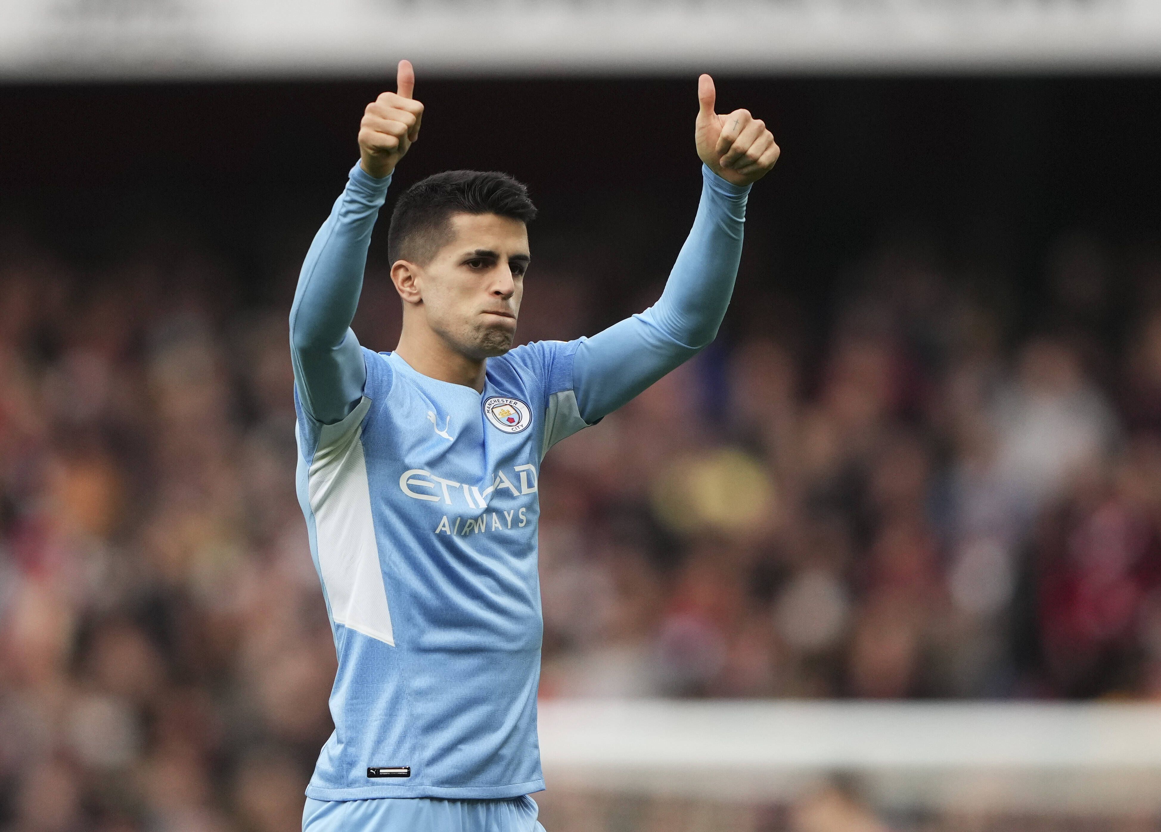 Fußballspieler Joao Cancelo steht auf einem Fußballfeld und jubelt.