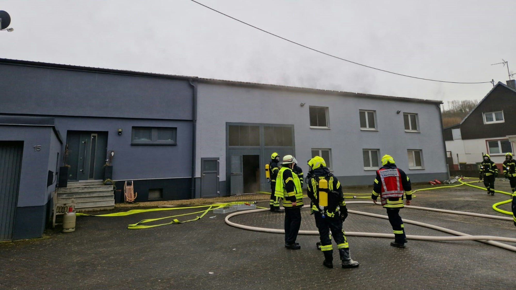Feuer in einer Erdgeschosswohnung. Feuerwehrleute löschen den Brand.