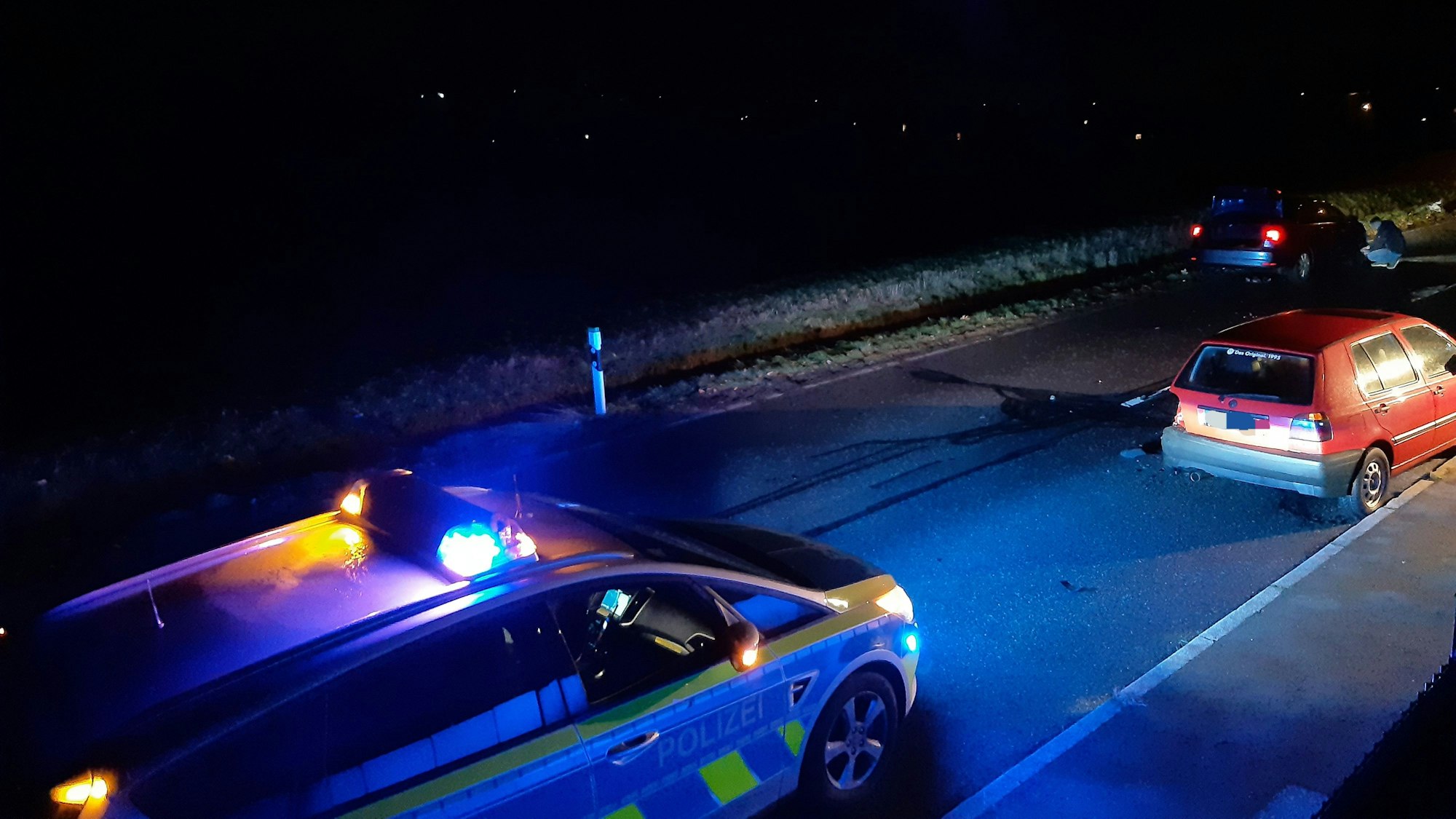 Ein Polizeifahrzeug sichert die Unfallstelle am Ortseingang Schmitzhöhe.