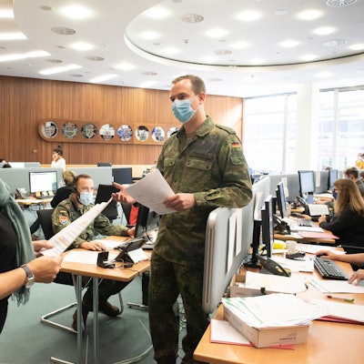 Soldaten der Bundeswehr helfen in einem Großraumbüro der Verwaltung des Rheinisch-Bergischen Kreises.