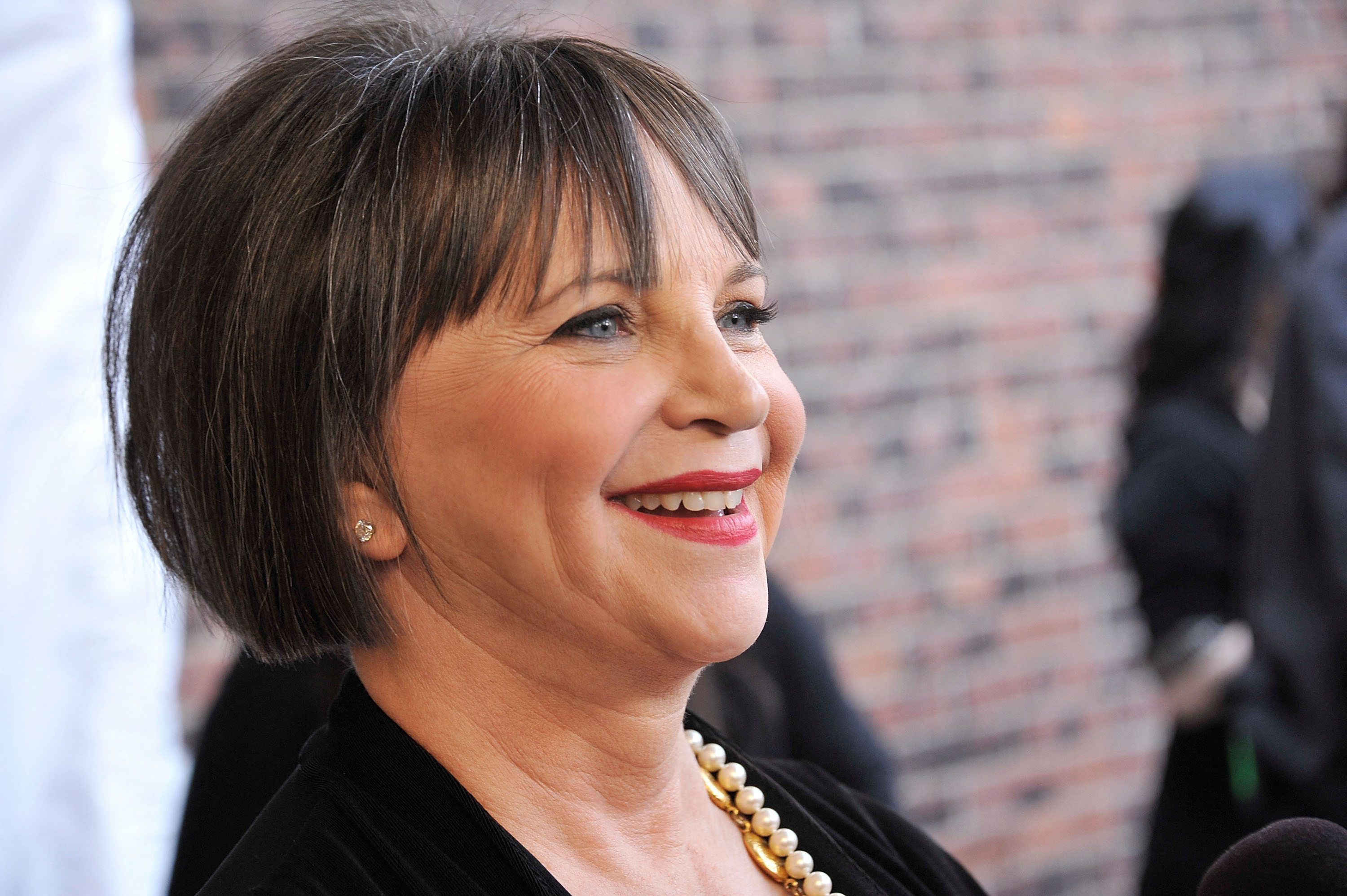Man sieht Cindy Williams von der Seite in Nahaufnahme, sie lächelt.