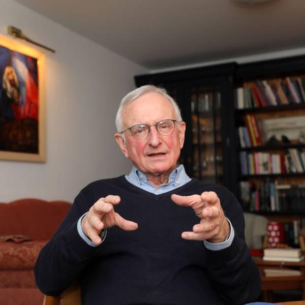 Der katholische Seelsorger Heinz-Peter Janßen sitzt im Wohnzimmer seines Hauses in Bergisch Gladbach-Herkenrath vor einer Bücherwand und spricht.