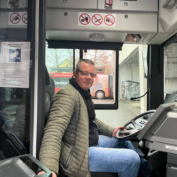 Busfahrer Nico Neumann sitzt am Steuer eines Linienbusses.