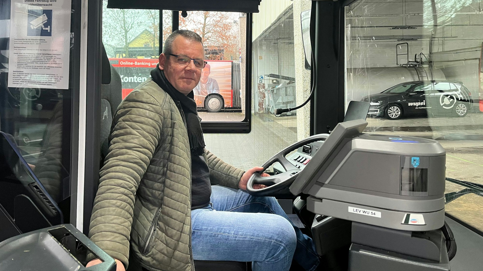 Busfahrer Nico Neumann sitzt am Steuer eines Linienbusses.