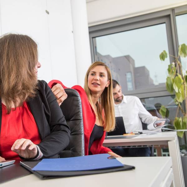 Zwei Frauen sitzen sich im Büro gegenüber.