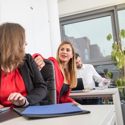 Zwei Frauen sitzen sich im Büro gegenüber.
