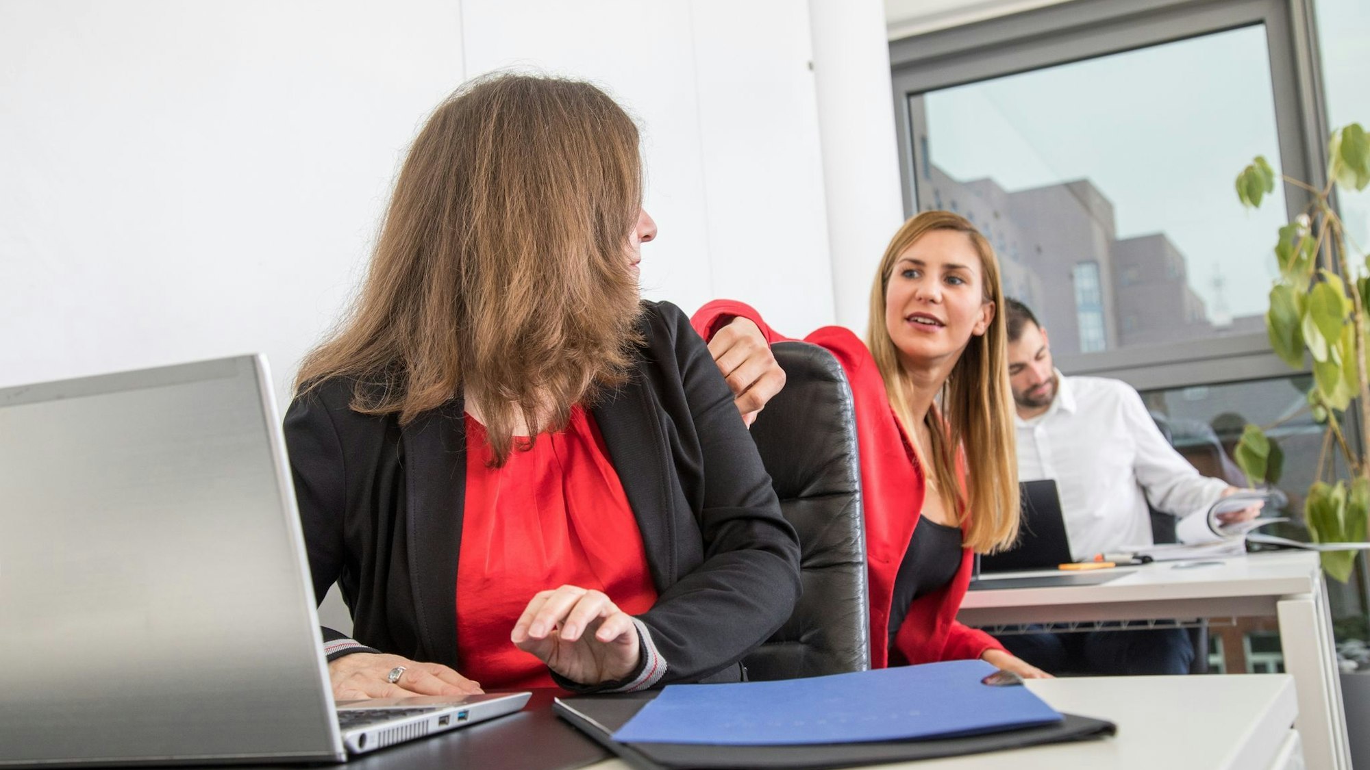 Zwei Frauen sitzen sich im Büro gegenüber.