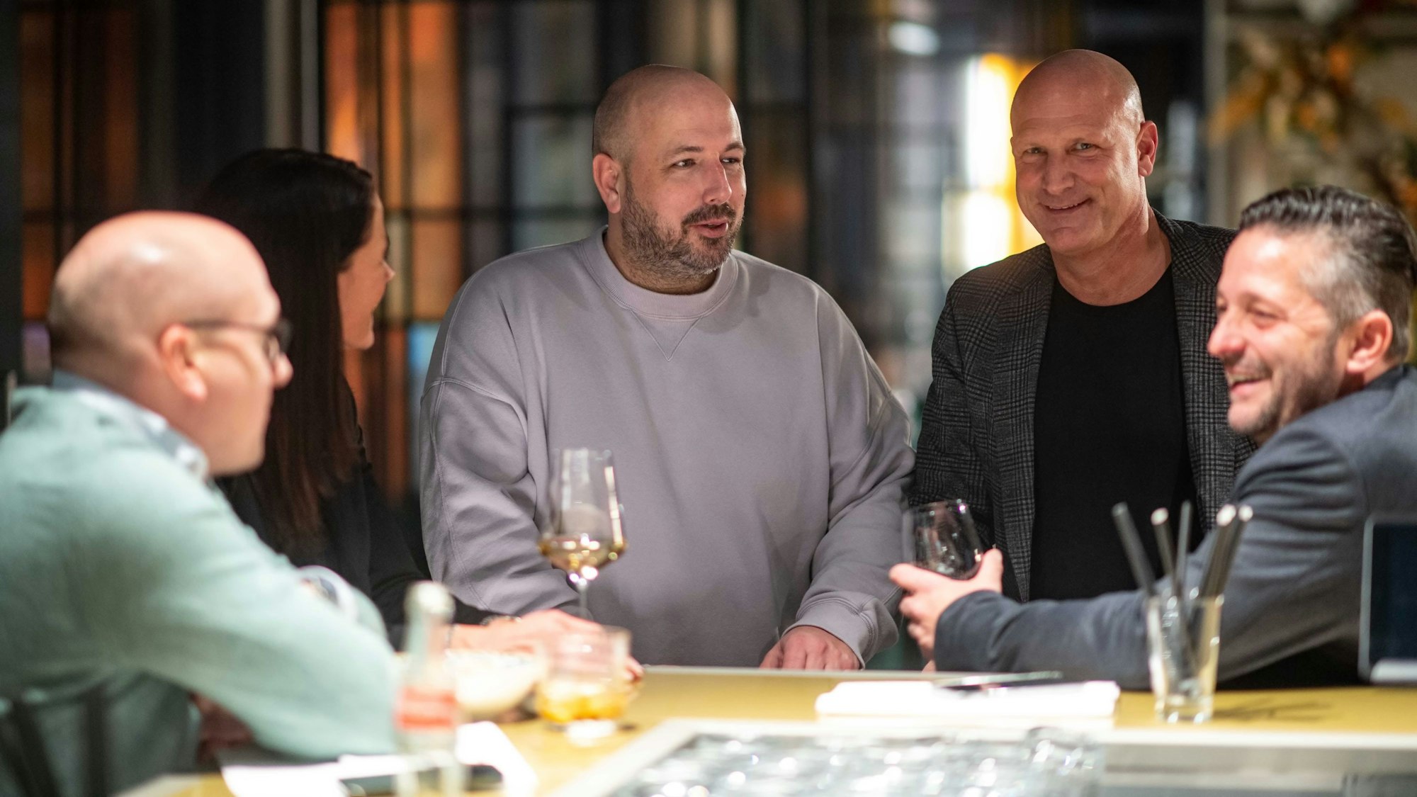 Die Macher des neuen Restaurants stehen an der Bar zusammen.