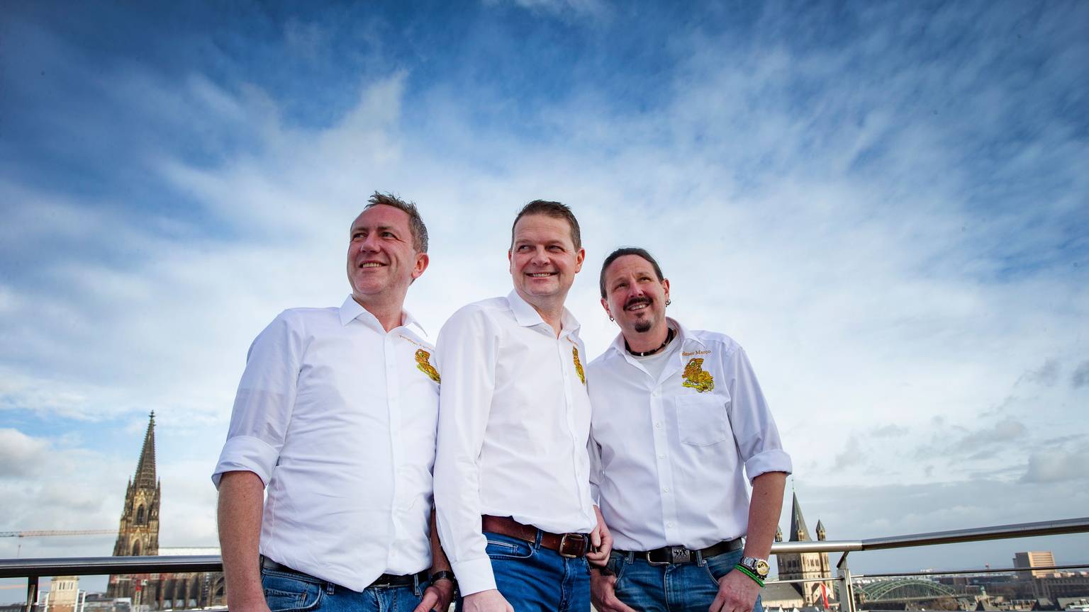 Prinz Boris Müller (Mitte), Bauer Marco Schneefeld (r.) und Jungfrau Andre Fahnenbruck auf dem Dach des Dorint-Hotels am Heumarkt. Im Hintergrund ist der Kölner Dom zu erkennen.