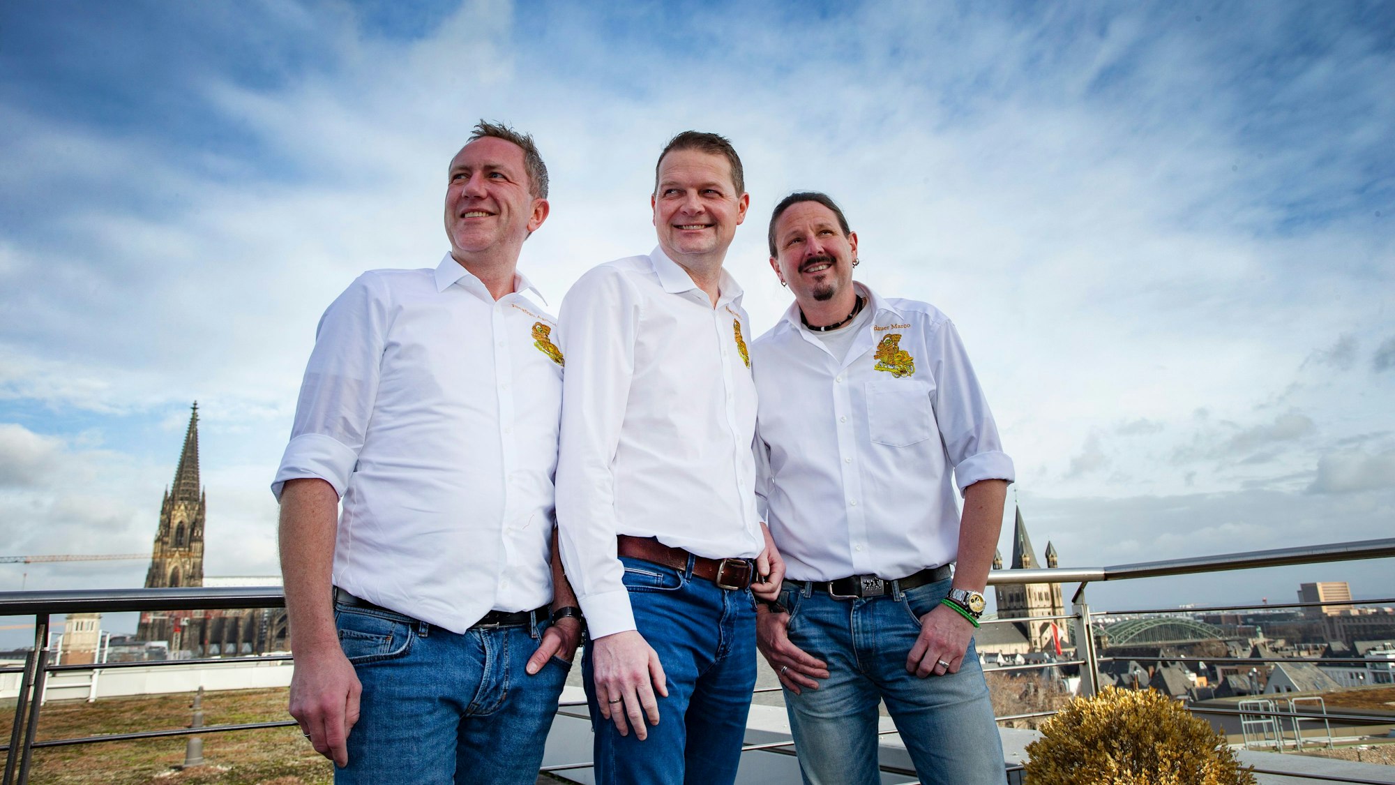 Prinz Boris Müller (Mitte), Bauer Marco Schneefeld (r.) und Jungfrau Andre Fahnenbruck auf dem Dach des Dorint-Hotels am Heumarkt. Im Hintergrund ist der Kölner Dom zu erkennen.