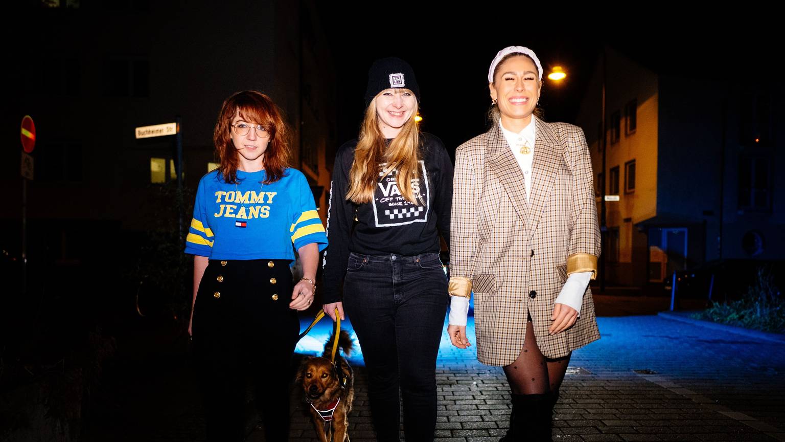 Trish Ross (von links), Jenny Gerdts und Linda Teodosiu sind gemeinsam mit Johanna Eicker Mätropolis. Die drei Frauen gehen eine dunkle Straße entlang.