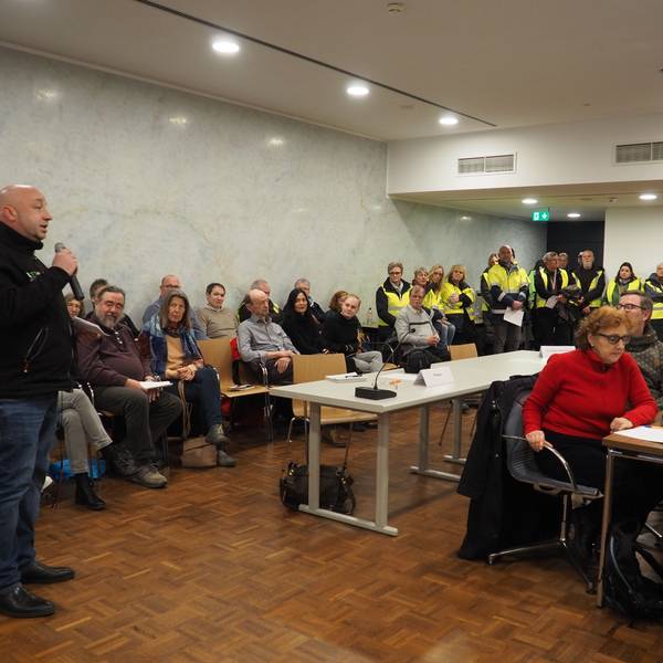 Tibor Schady warb in der Sitzung des Erftstädter Stadtrats um Unterstützung für das Spendenlager. Im Hintergrund sind zahlreiche Helfer zu sehen.