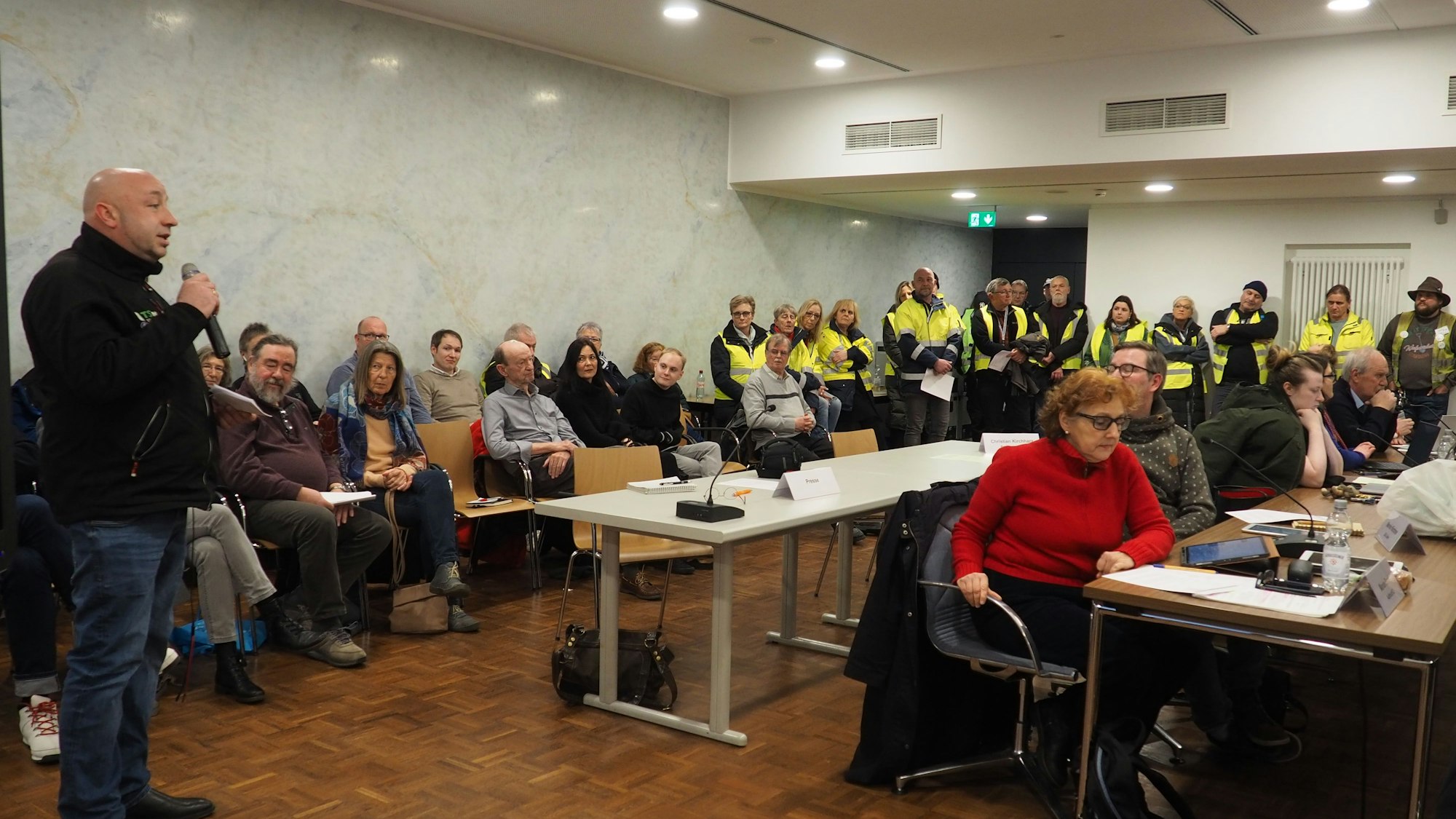 Tibor Schady warb in der Sitzung des Erftstädter Stadtrats um Unterstützung für das Spendenlager. Im Hintergrund sind zahlreiche Helfer zu sehen.