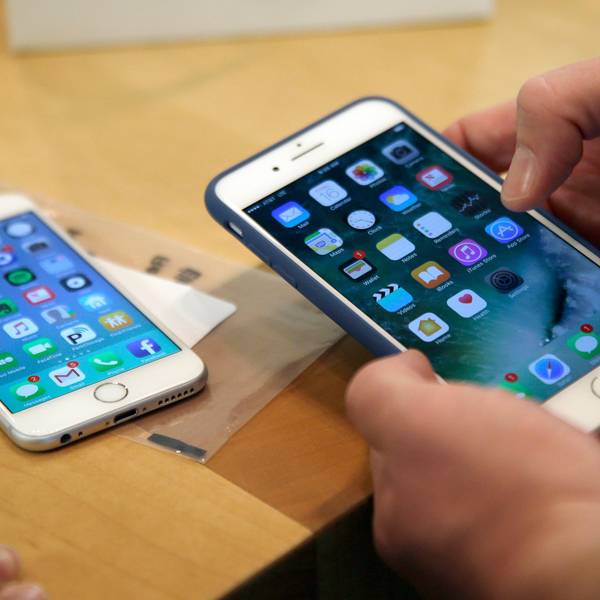 Ein Kunde richtet sein neues iPhone 7 Plus (r) ein, während sein altes iPhone 6 auf einem Tisch liegt.