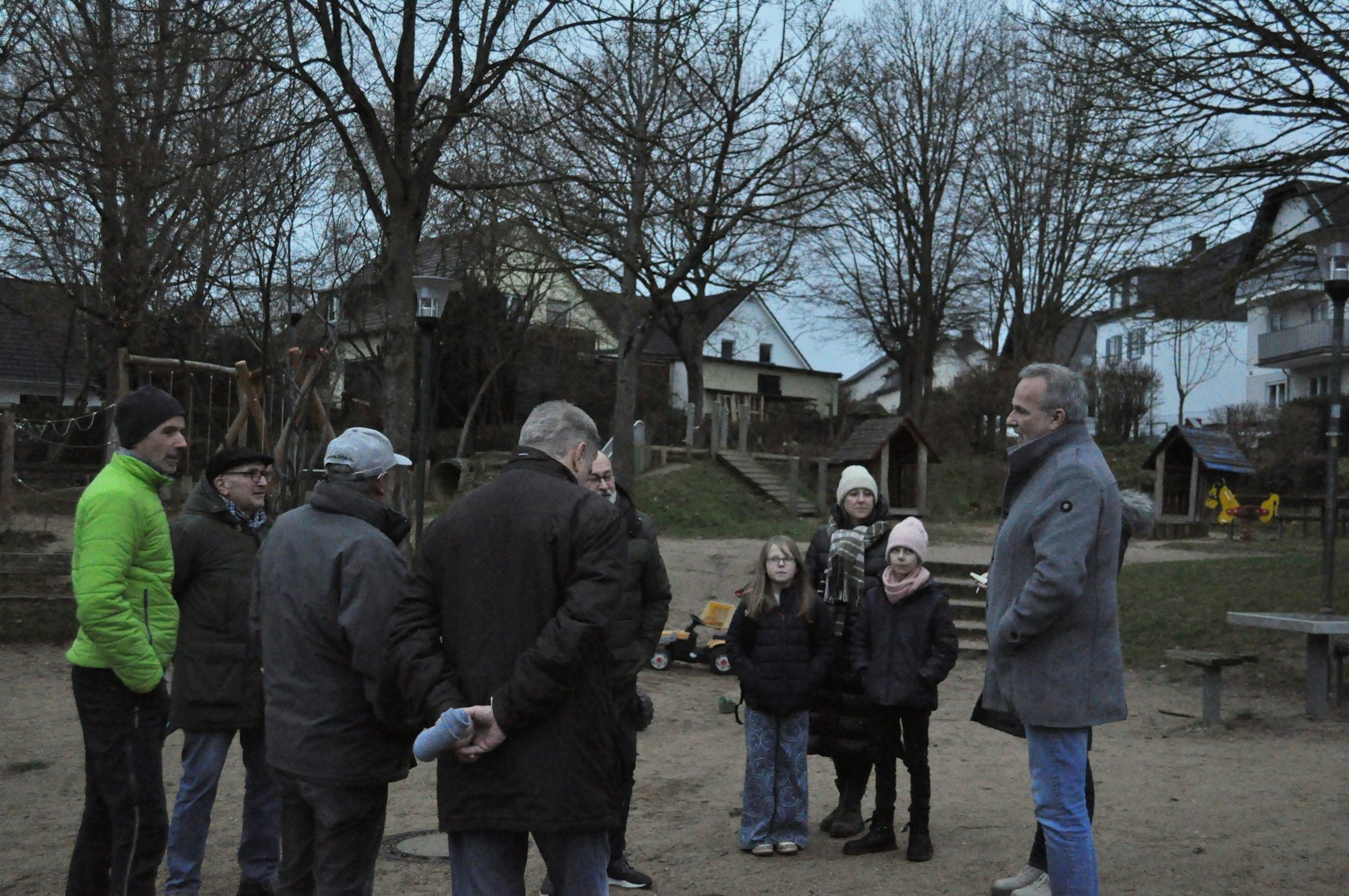 Mit hochgeschlagenem Kragen stand Bürgermeister Jörg Schmidt im Regen bei einbrechender Dunkelheit den Werthhovenern Rede und Antwort.