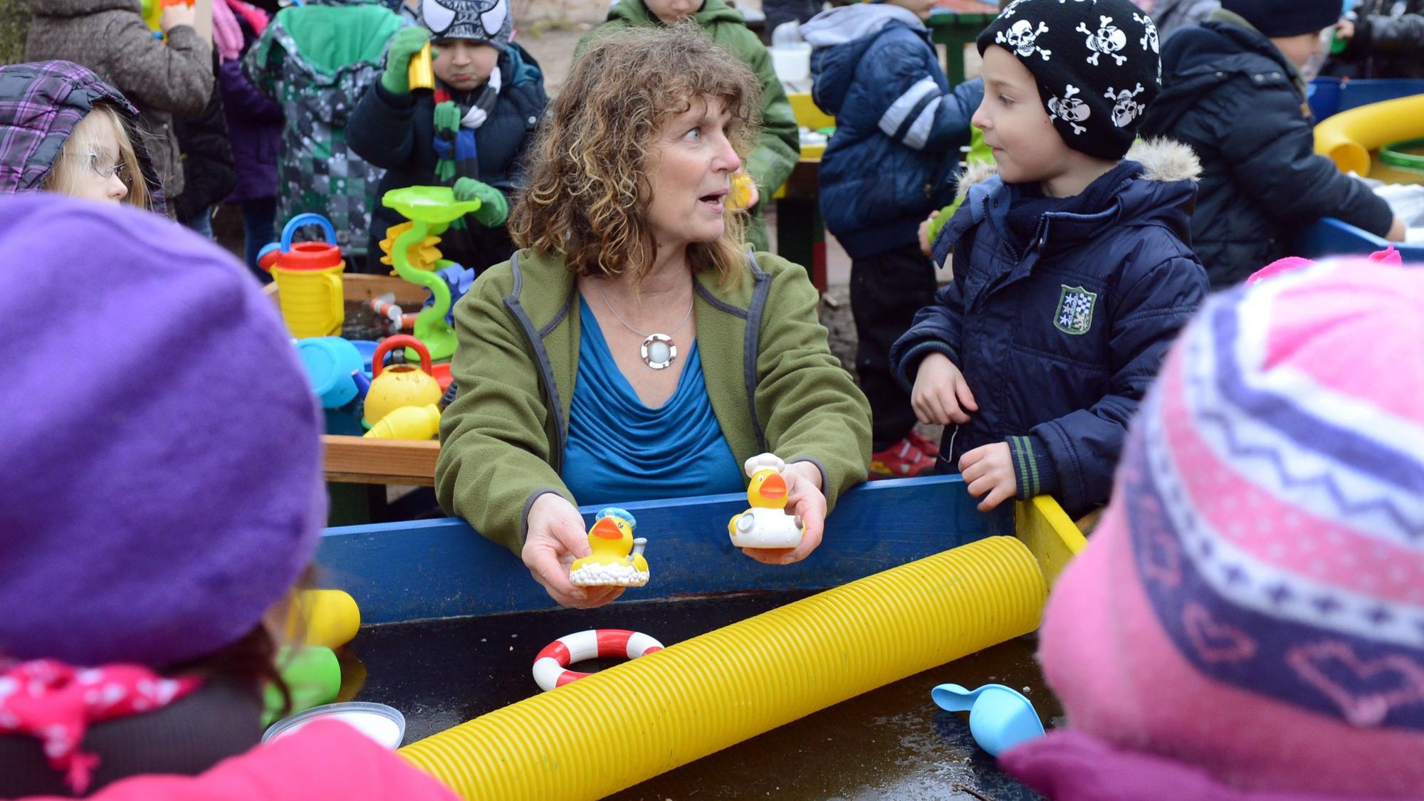 Eine Erzieherin spielt mit Kindern.
