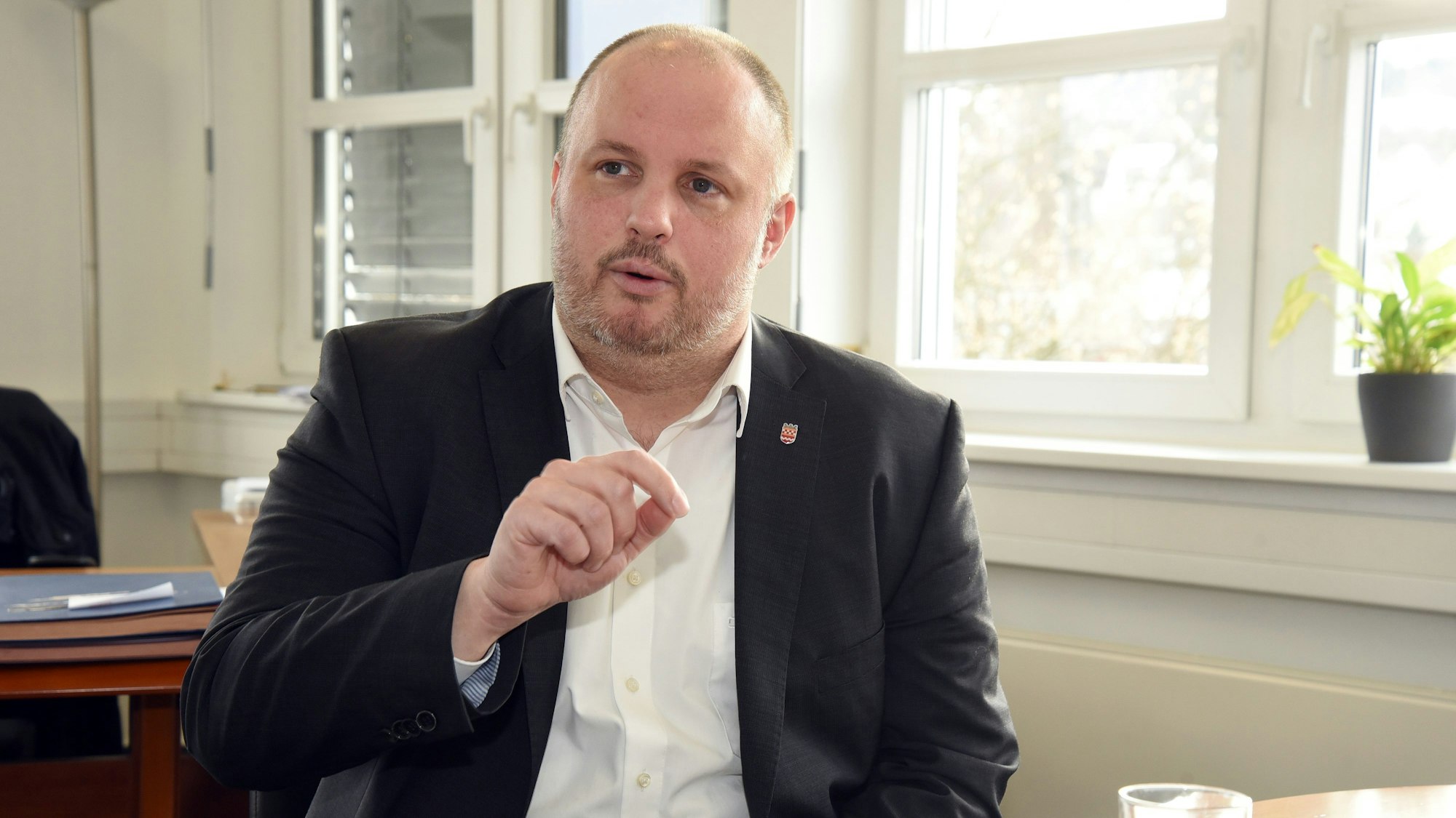 Ein Mann sitzt in einem Büro an einem Tisch.