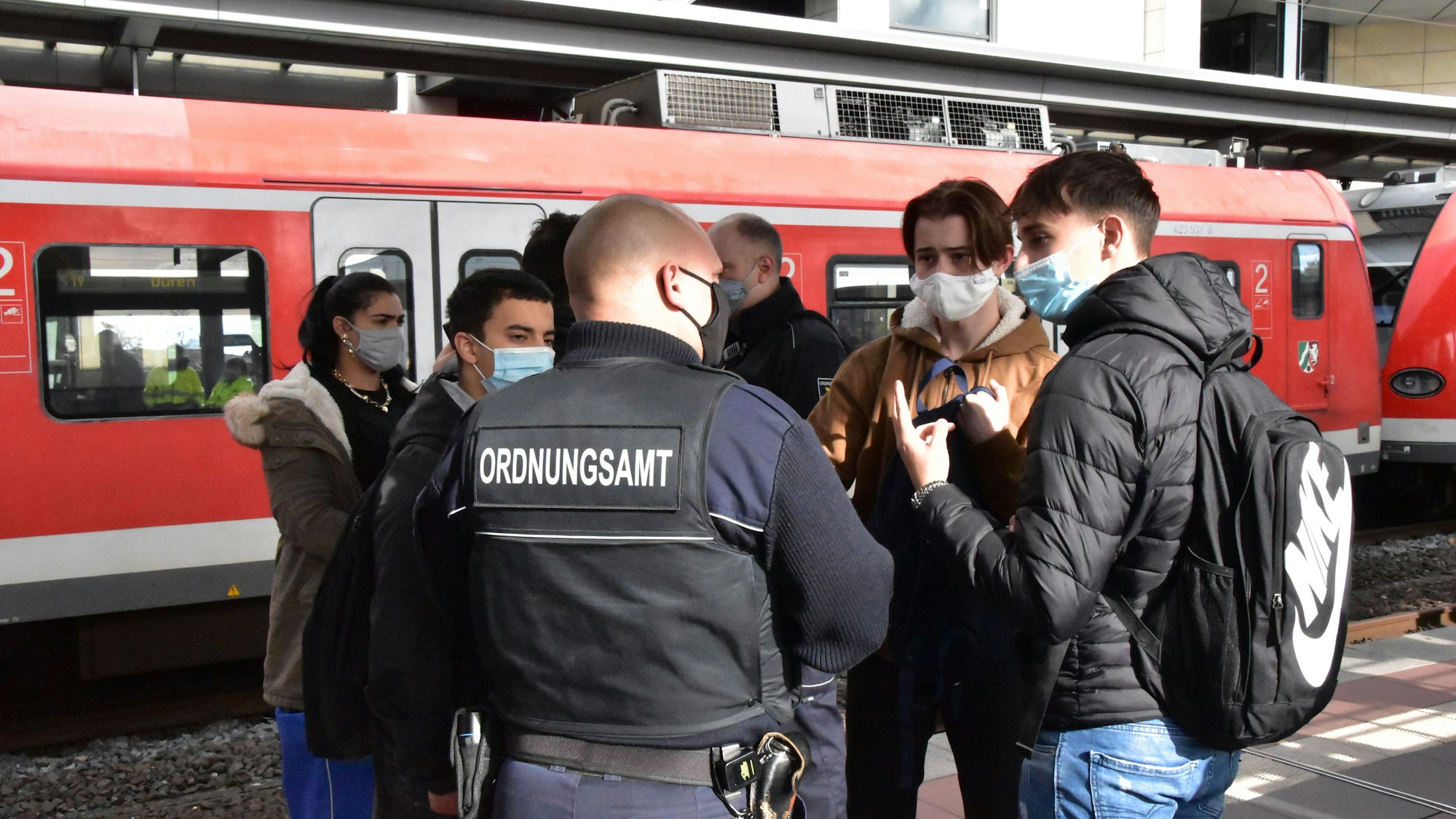 Ordnungsamt und DB-Sicherheit bei einer Maskenkontrolle am Bahnhof Siegburg.