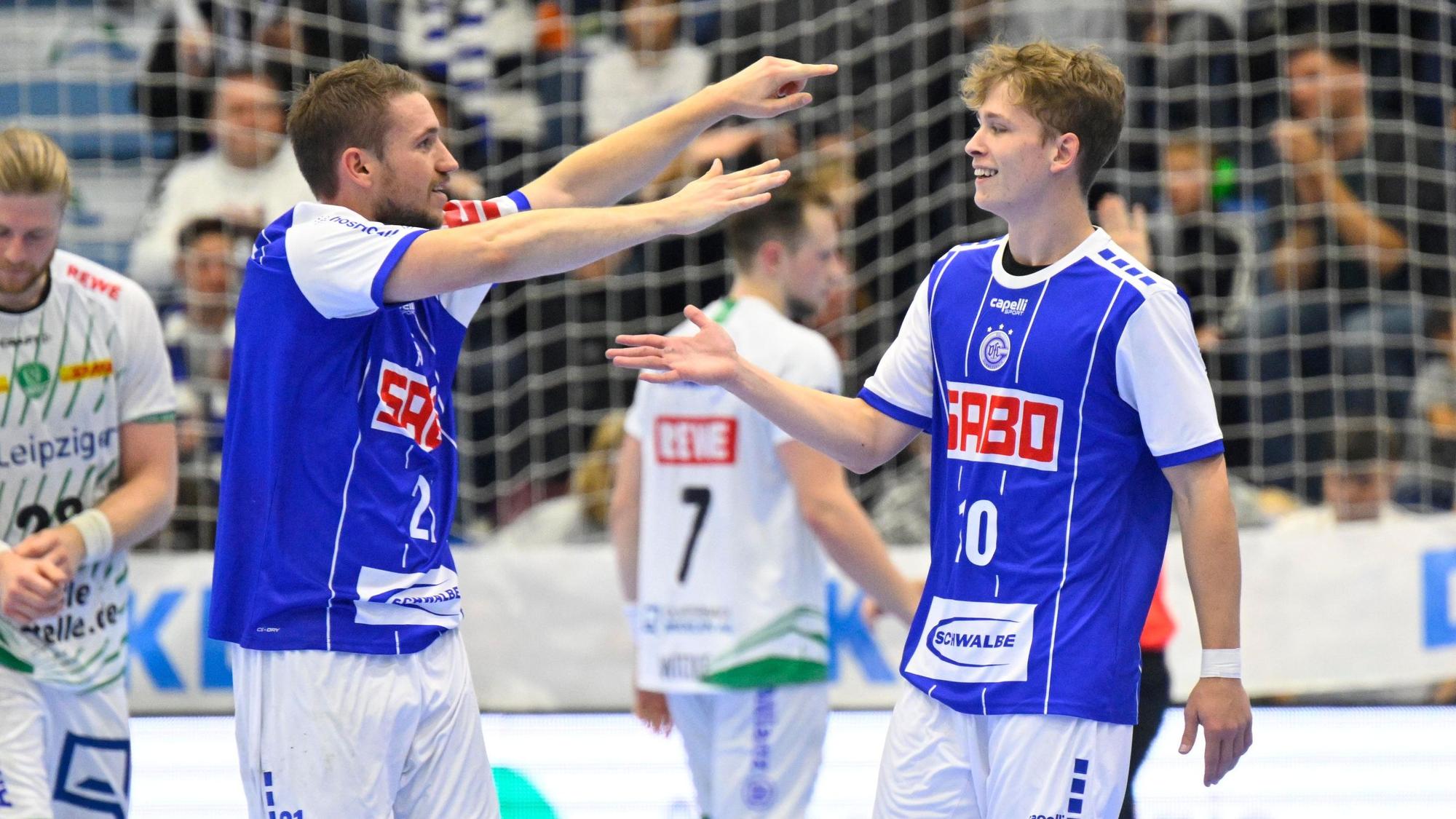 Dominik Mappes, Handballspieler des VfL Gummersbach, läuft bei einem Spiel mit ausgebreiteten Fänden auf seinen Mannschaftskollegen Finn Schroven zu.