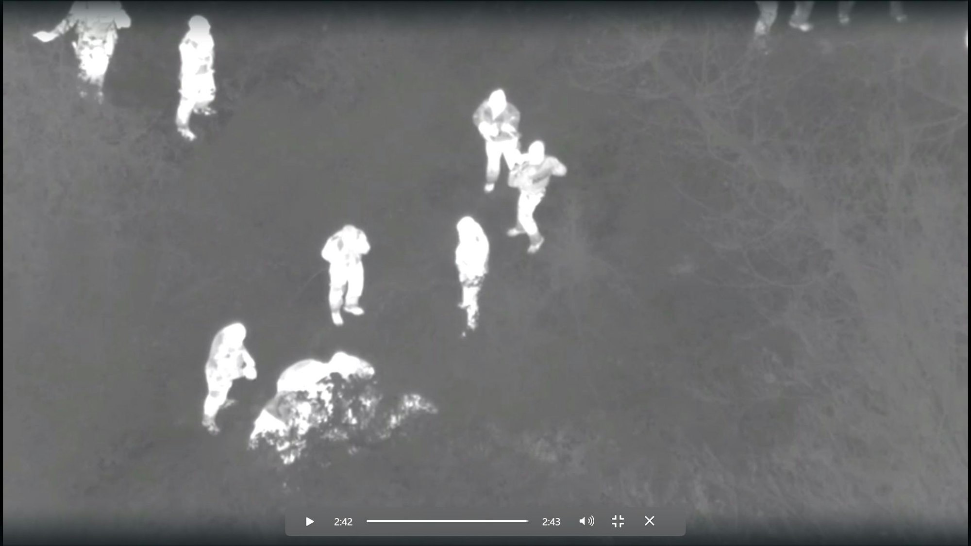 In einer Schwarz-Weiß-Darstellung sind helle Menschen vor grauem Grund zu sehen.