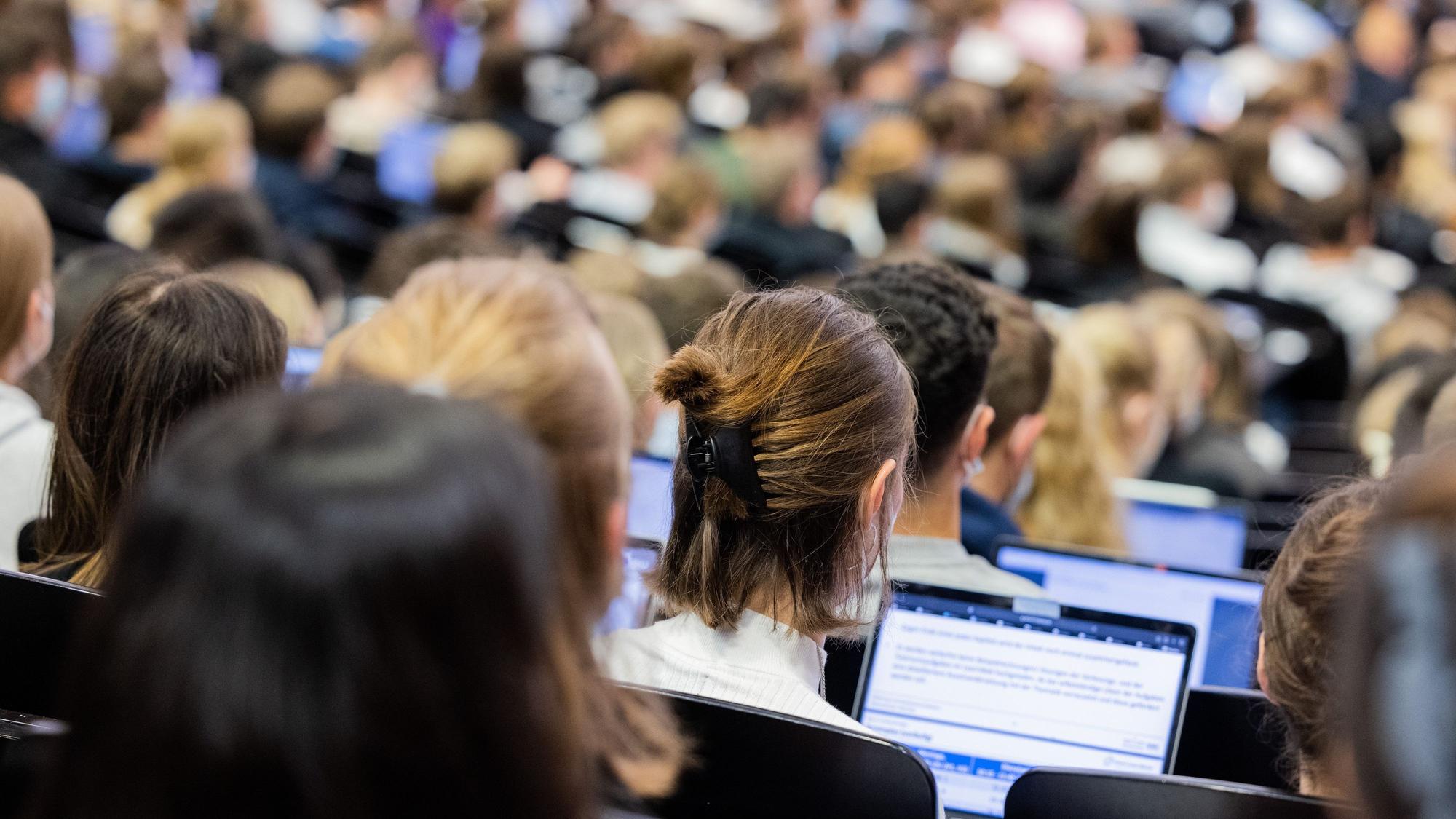 Die Studierenden sitzen dicht nebeneinander bei einer Vorlesung.