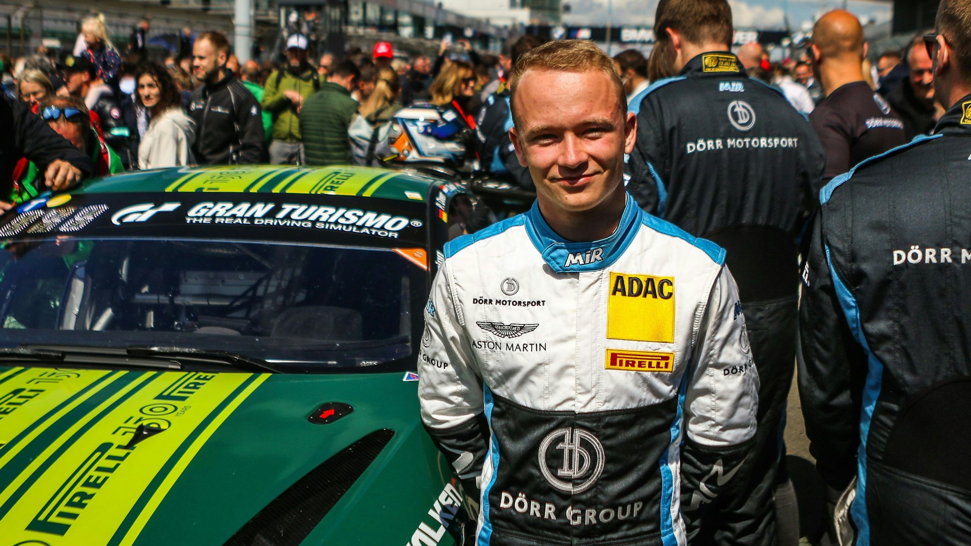 Rennfahrer Moritz Wiskirchen steht am Nürburgring vor seinem Auto.