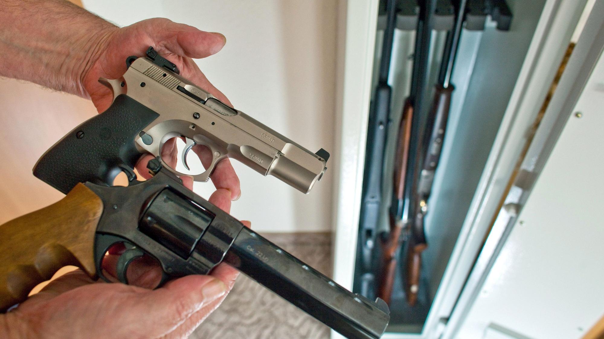 Ein Revolver und eine Pistole werden vor die Kamera gehalten