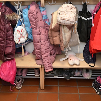 Das Foto zeigt Jacken und Mäntel, die Kinder in einer Kita vor ihrem Raum aufgehängt haben.