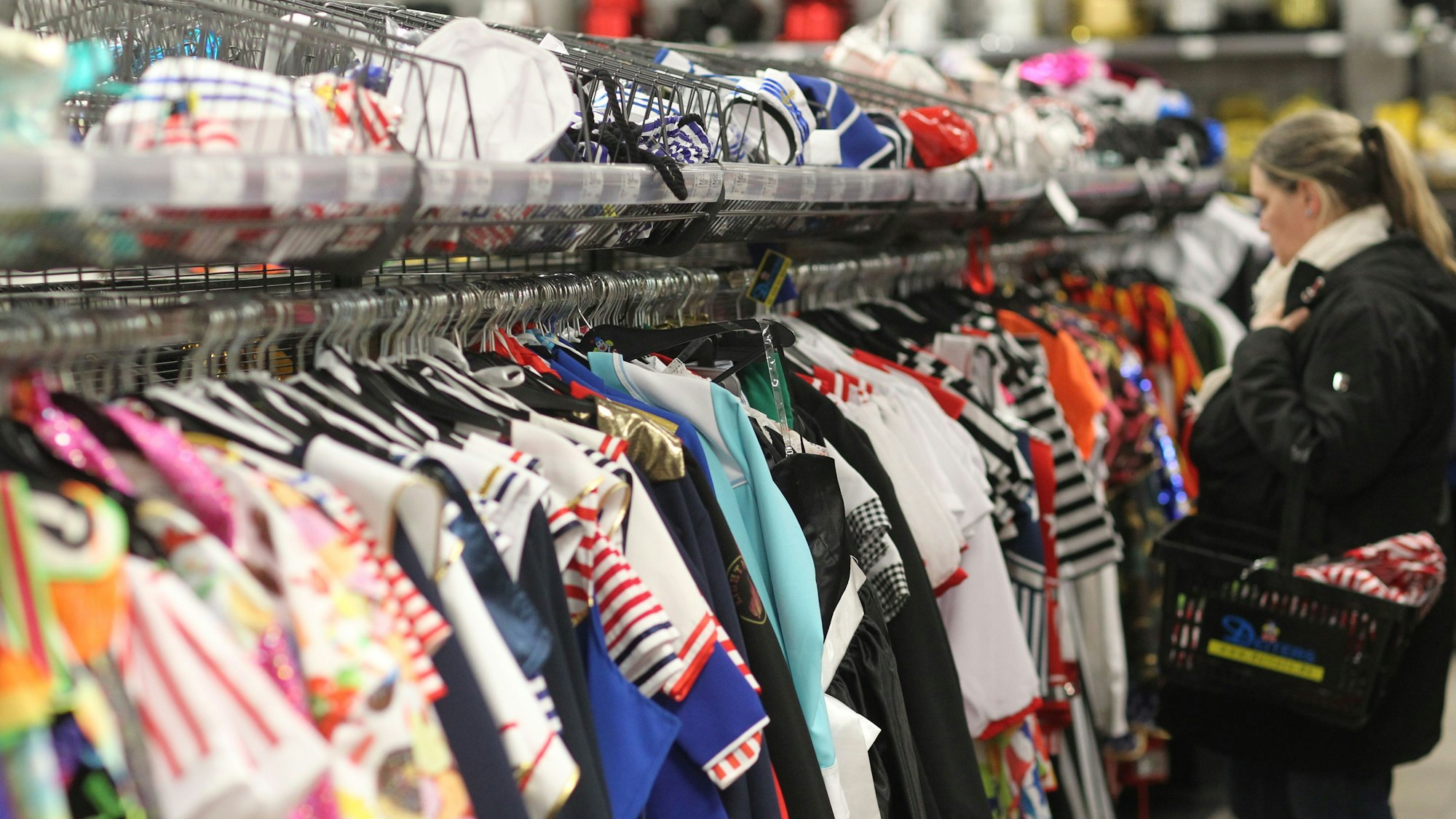 Eine Frau kauft in einem Karnevalsgeschäft ein.