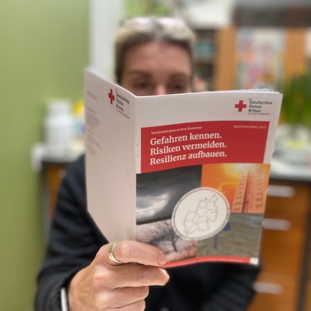 Die neue DRK-Broschüre wird in die Kamera gehalten. In der Broschüre geht es um Tipps für mögliche Krisensituationen.