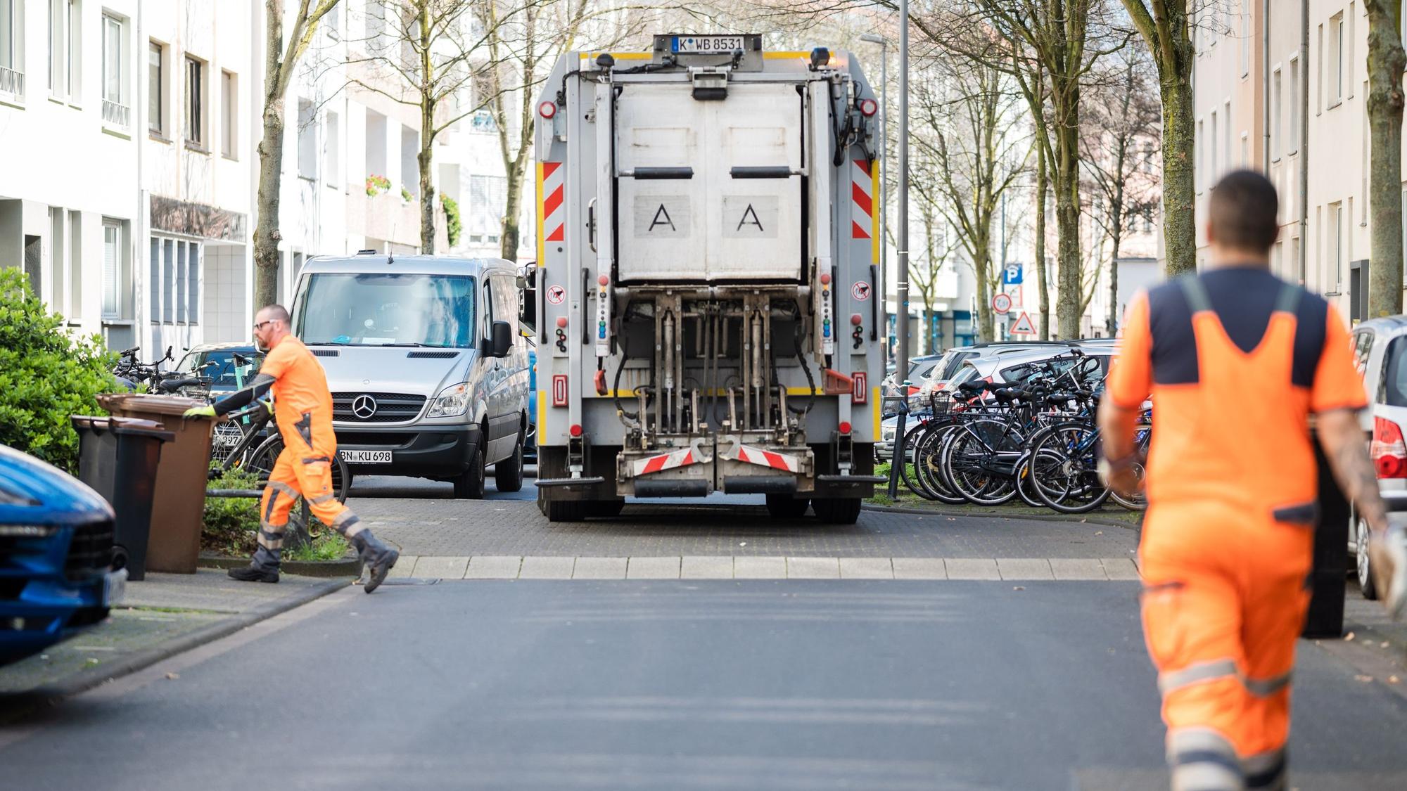 Mitarbeiter der Kölner Abfallwirtschaftsbetriebe (AWB) bei der Leerung von Mülltonnen.