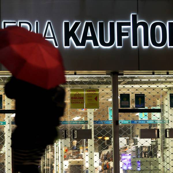 ARCHIV - 27.01.2021, Nordrhein-Westfalen, Köln: Eine Frau geht mit Regenschirm an einer geschlossenen Kaufhof Filiale vorbei.