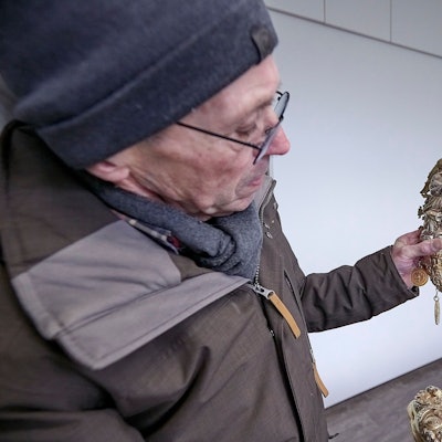 Ein Mann hält eine Monstranz, die nach der Flut von 2021 noch deutliche Schlammspuren trägt.