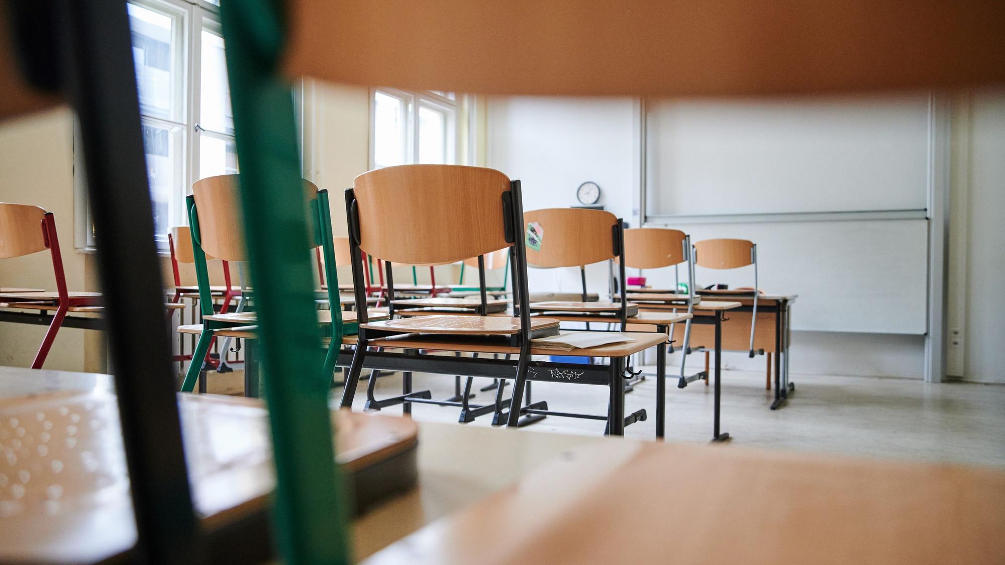 In einem Klassenzimmer stehen die Stühle auf den Tischen.